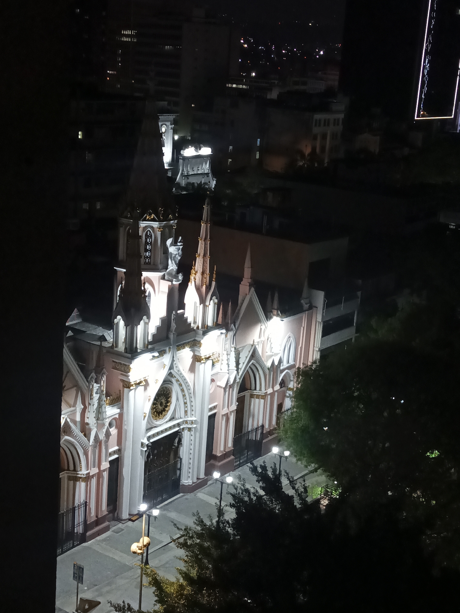 Nighttime documentation captures illuminated church and Caracas cityscape