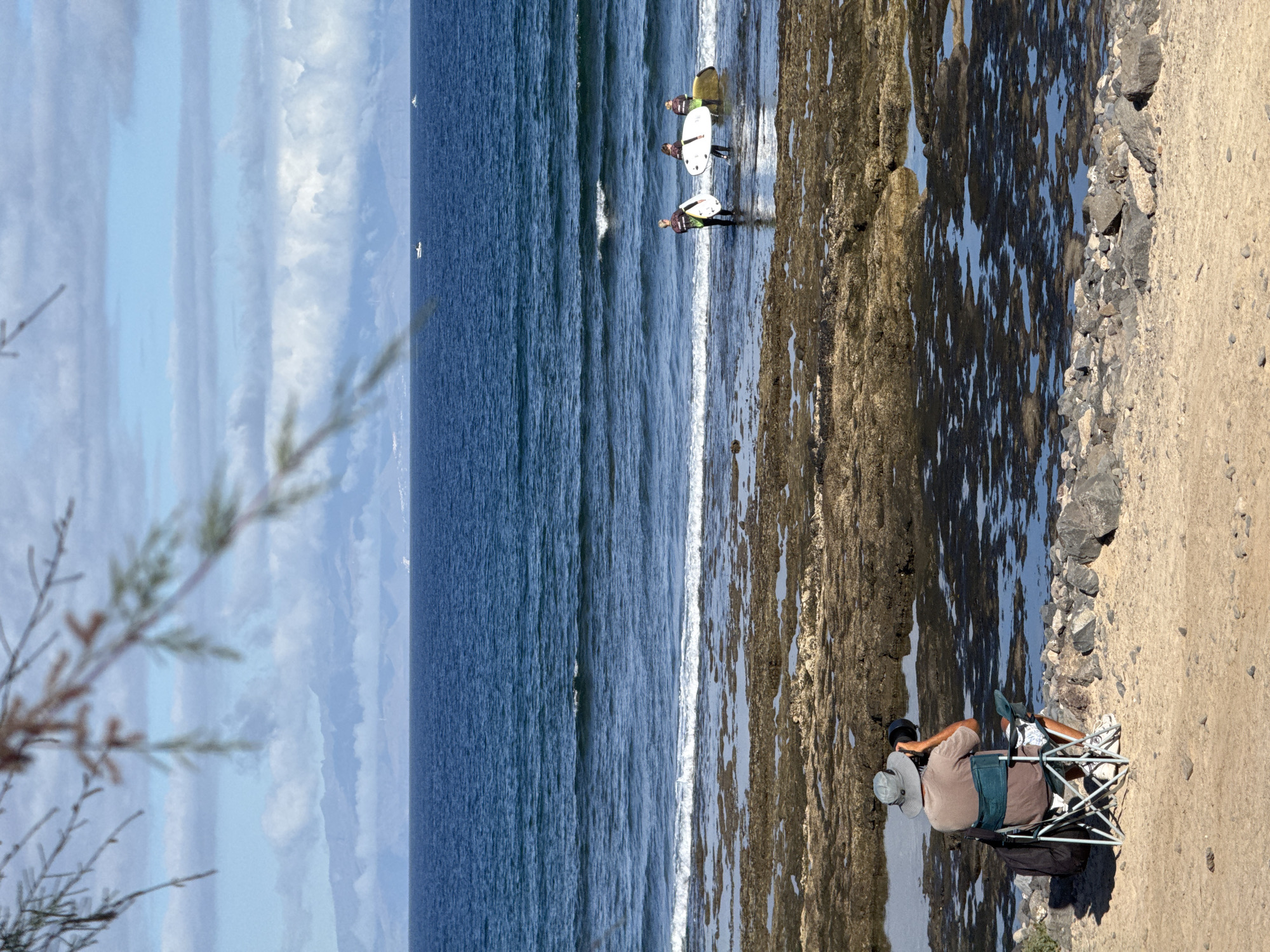Relaxing on a rocky Arona shoreline with ocean views