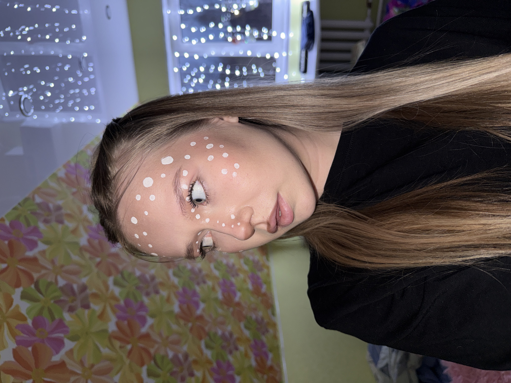 Woman poses with painted white dots on face in Zhigalki