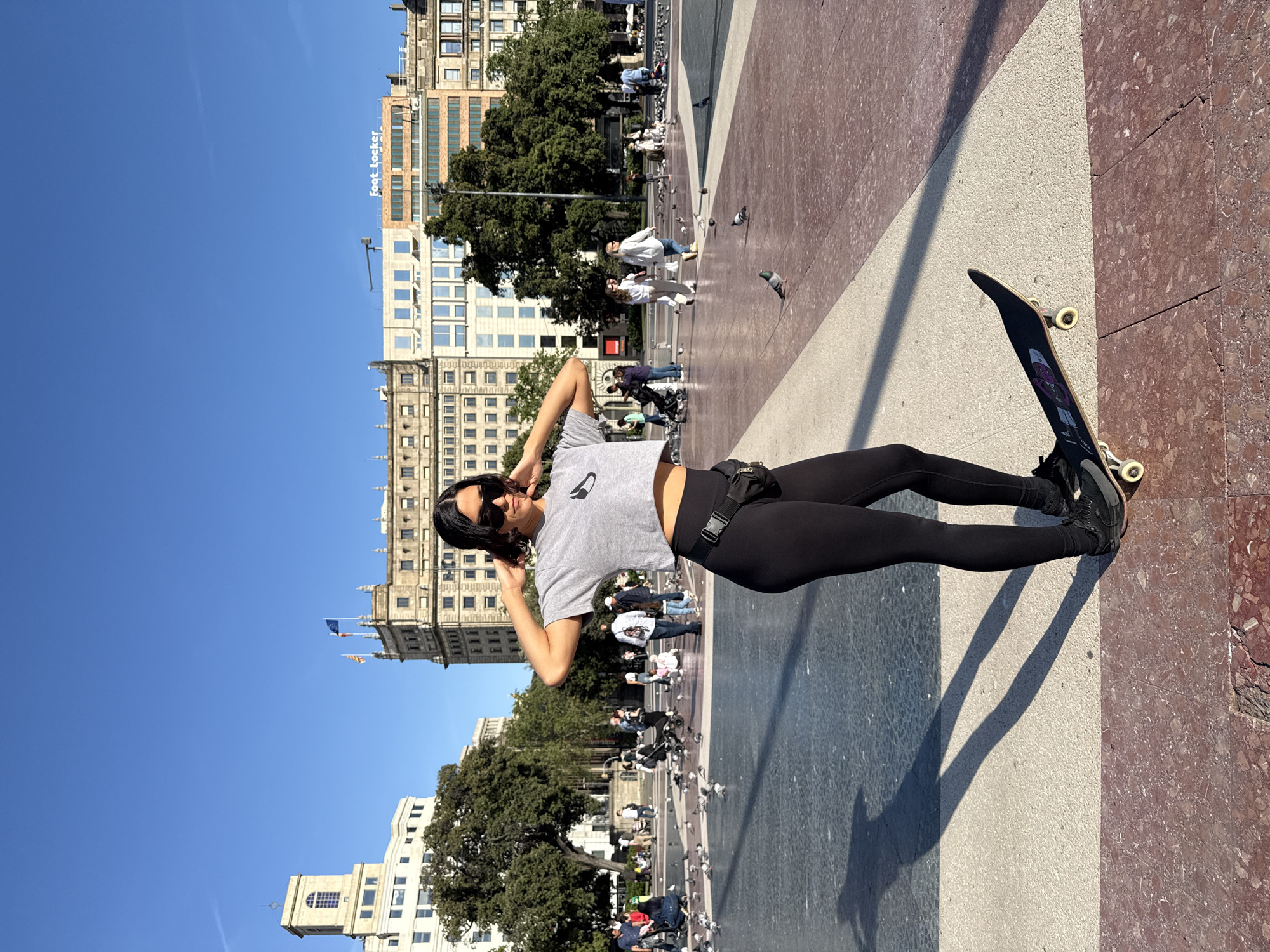 Woman skateboards, films content in Barcelona's Plaça de Catalunya