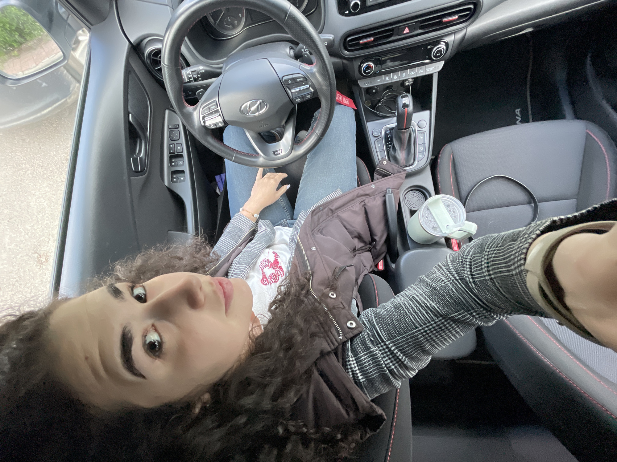 Woman makes peace sign in car, Sofia morning