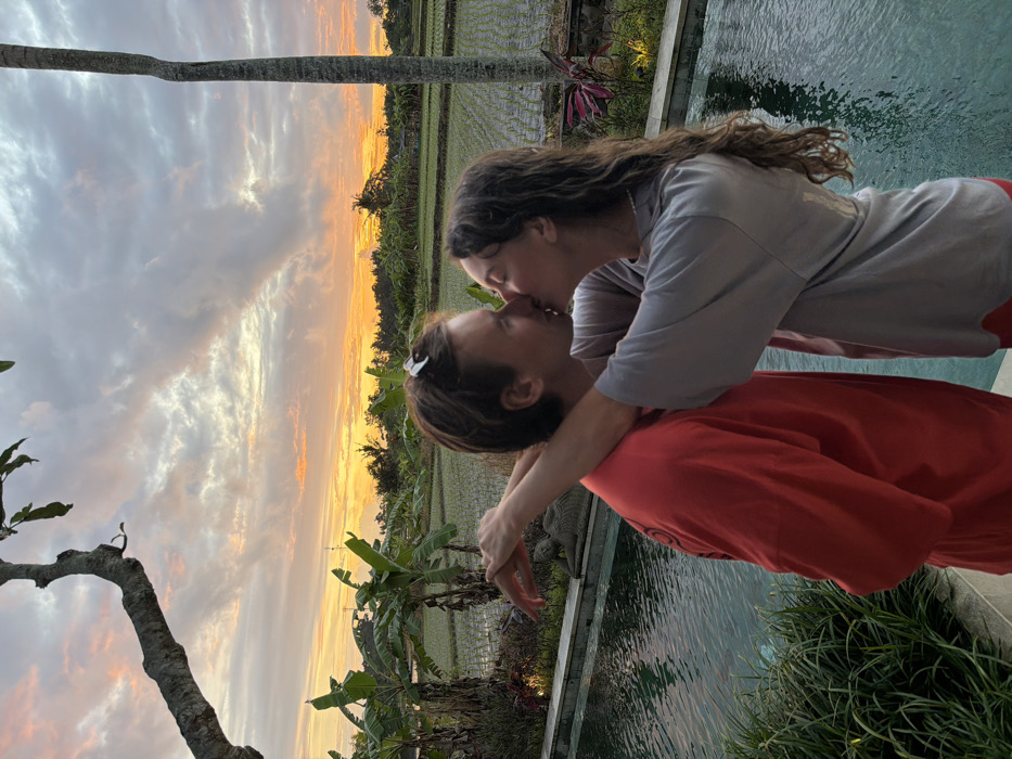 Tourists enjoy pool activities at Mas villa overlooking rice fields