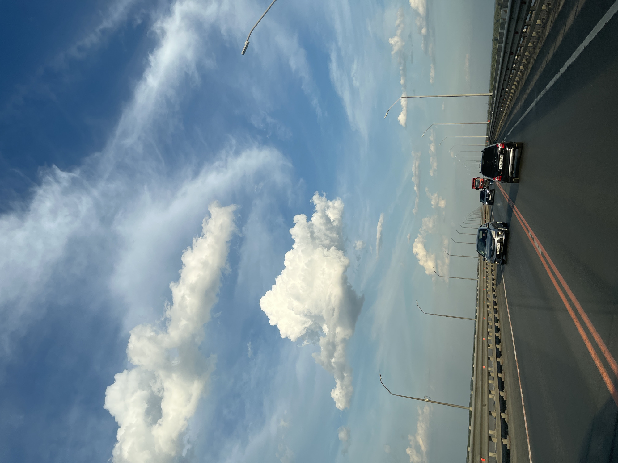 Crossing a river bridge near Пристанное under summer skies