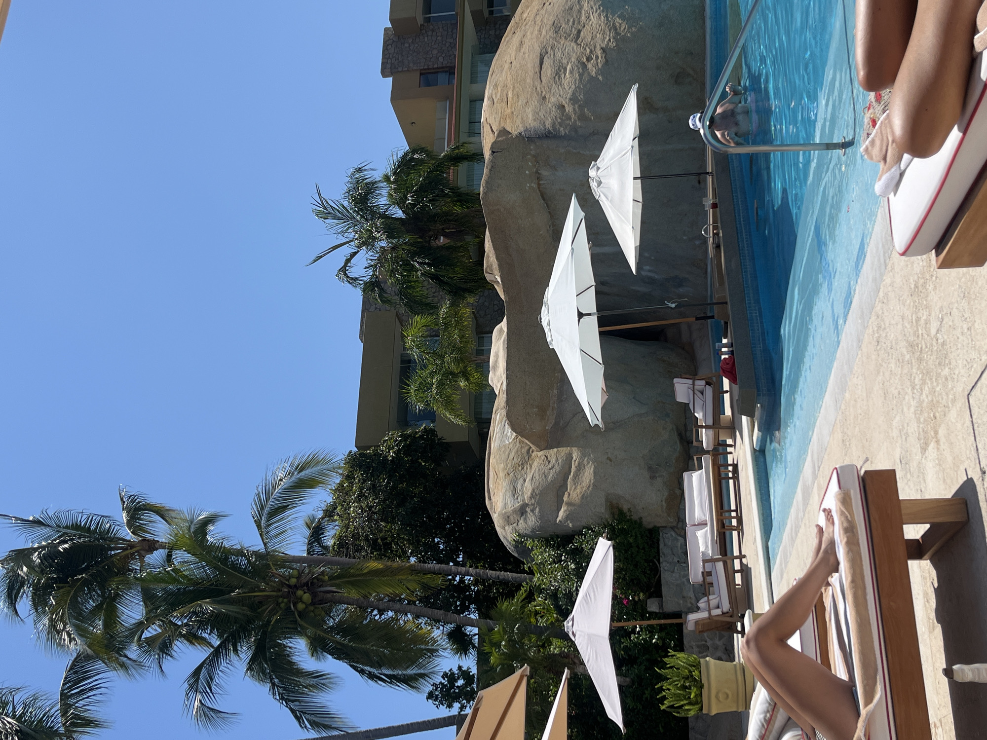 Resort guests relax poolside with drinks in Acapulco