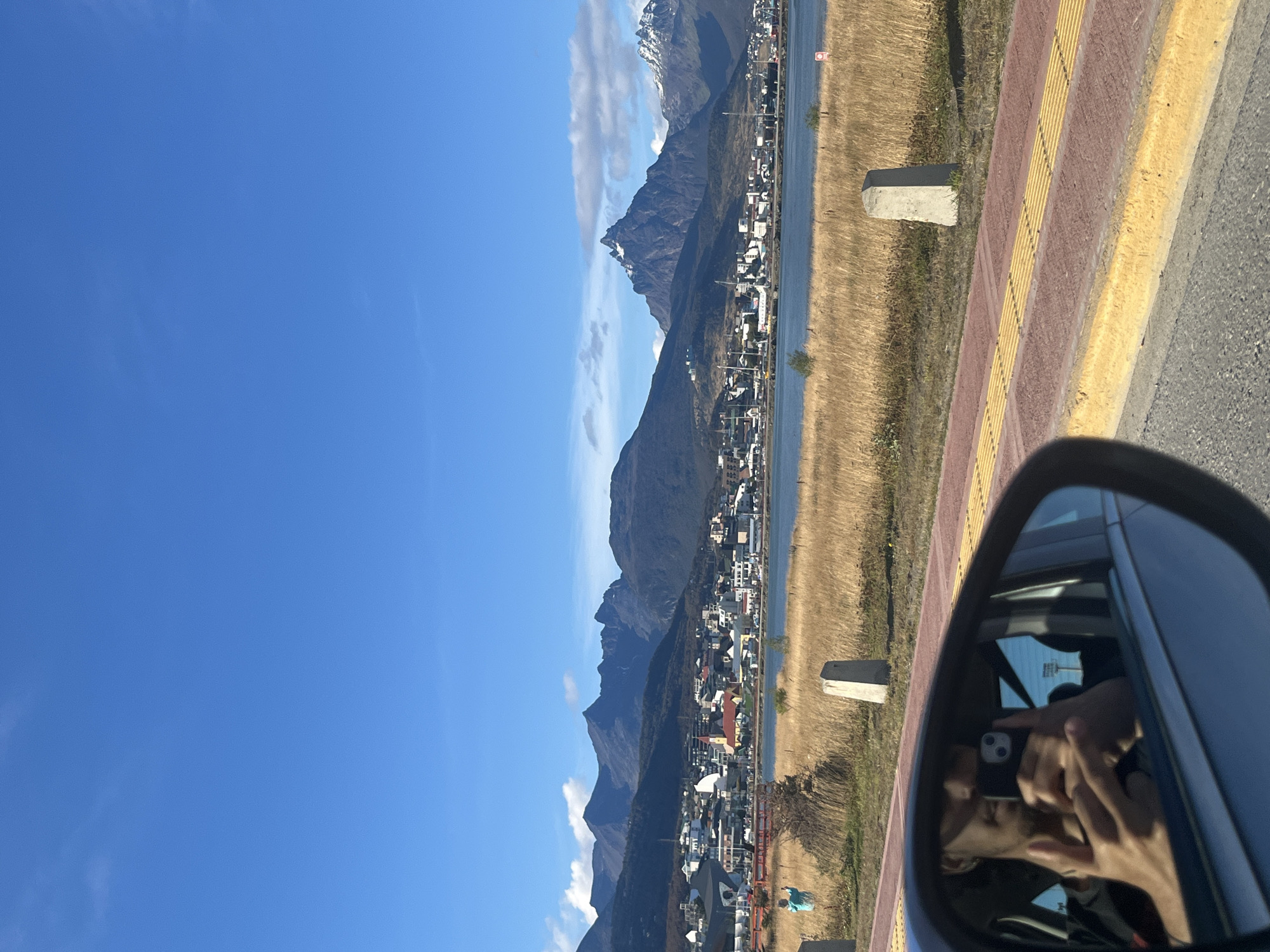 Ushuaia landscape viewed through car mirror shows mountains, water