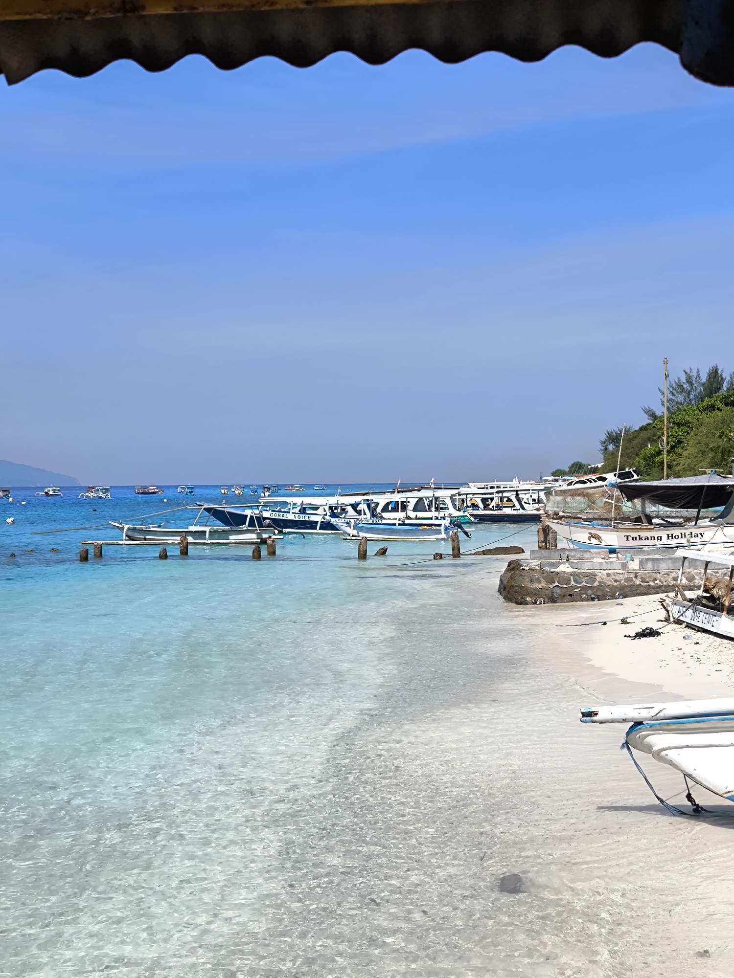 Peaceful Indonesian beach scene captured with boats visible offshore