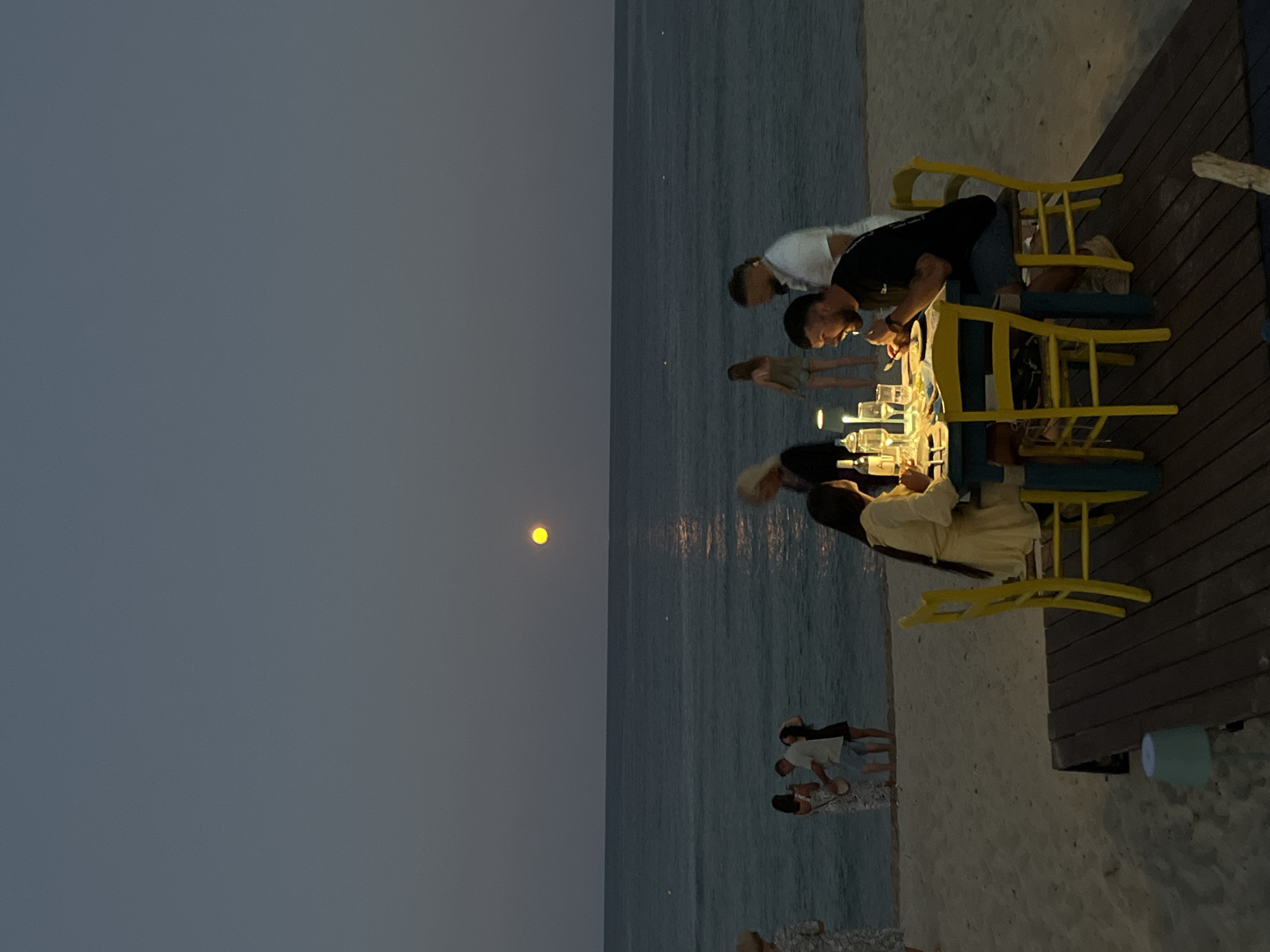 Full moon rising over a beachside dinner in Toroni