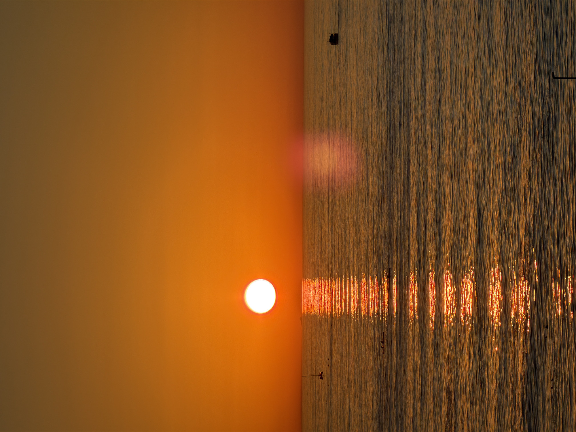 Cape Town sunset viewed over ocean with wooden posts