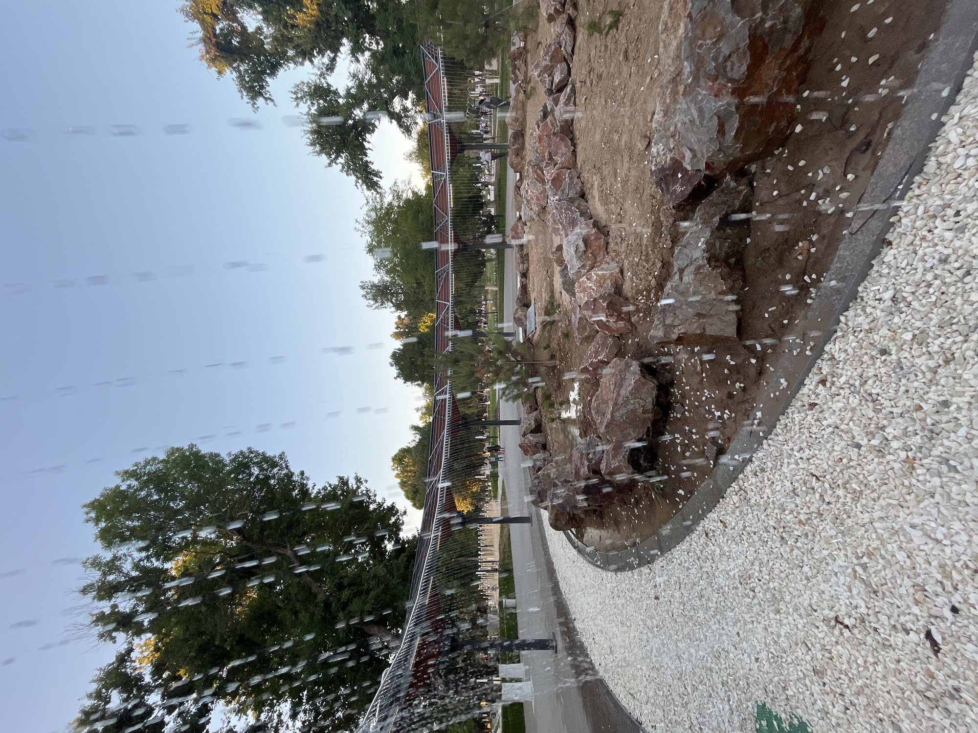 Shymkent park fountain and gravel paths on a wet afternoon