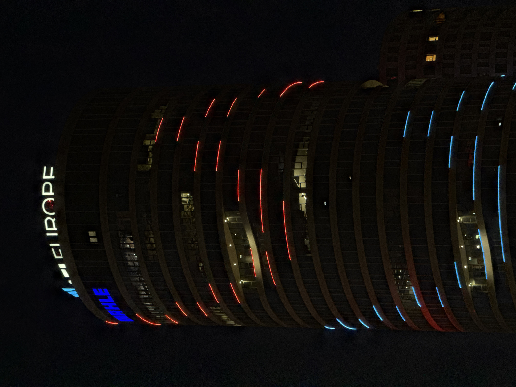 Modern Belgrade high-rise illuminated at night displays curved facade