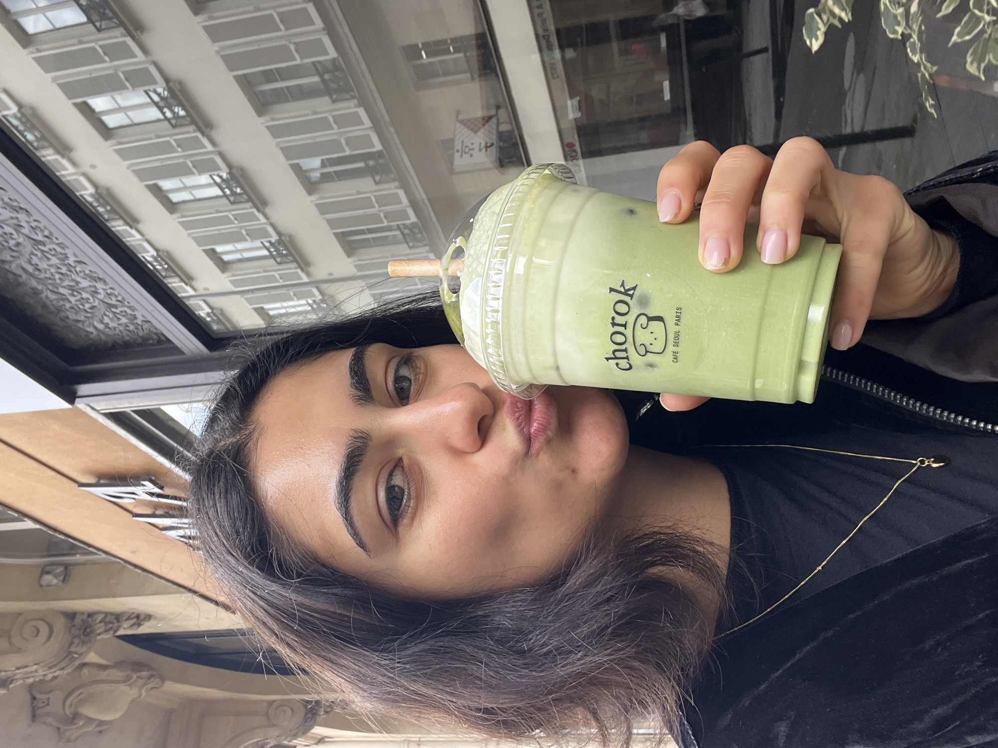 Woman enjoys matcha latte at Korean cafe in Paris