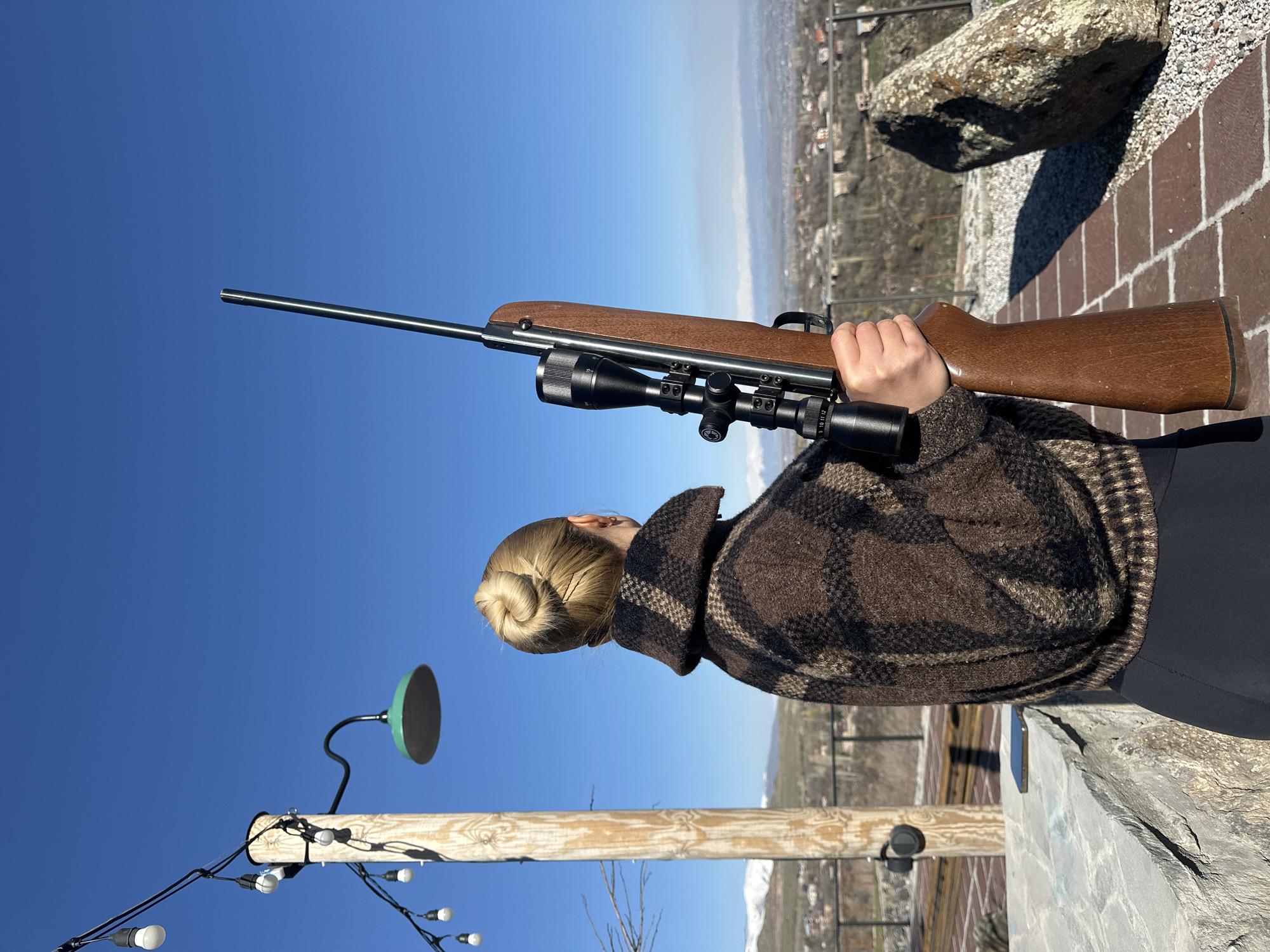 Woman with rifle spotted overlooking landscape in Byurakan, Armenia