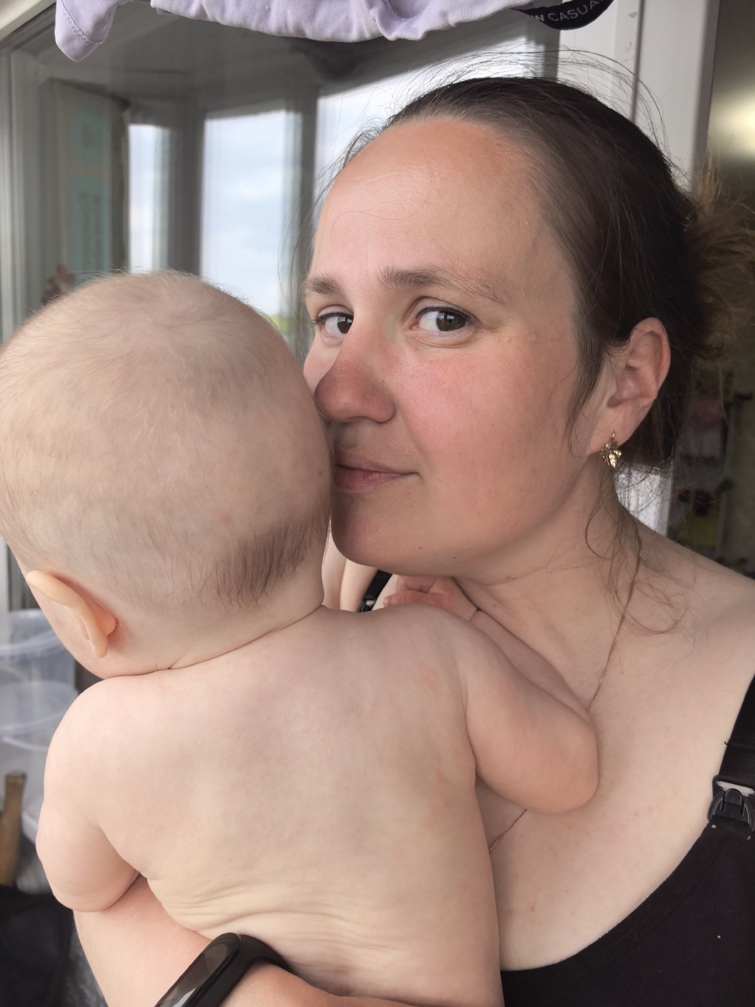 Mother holds baby close in tender moment, Frolы Russia
