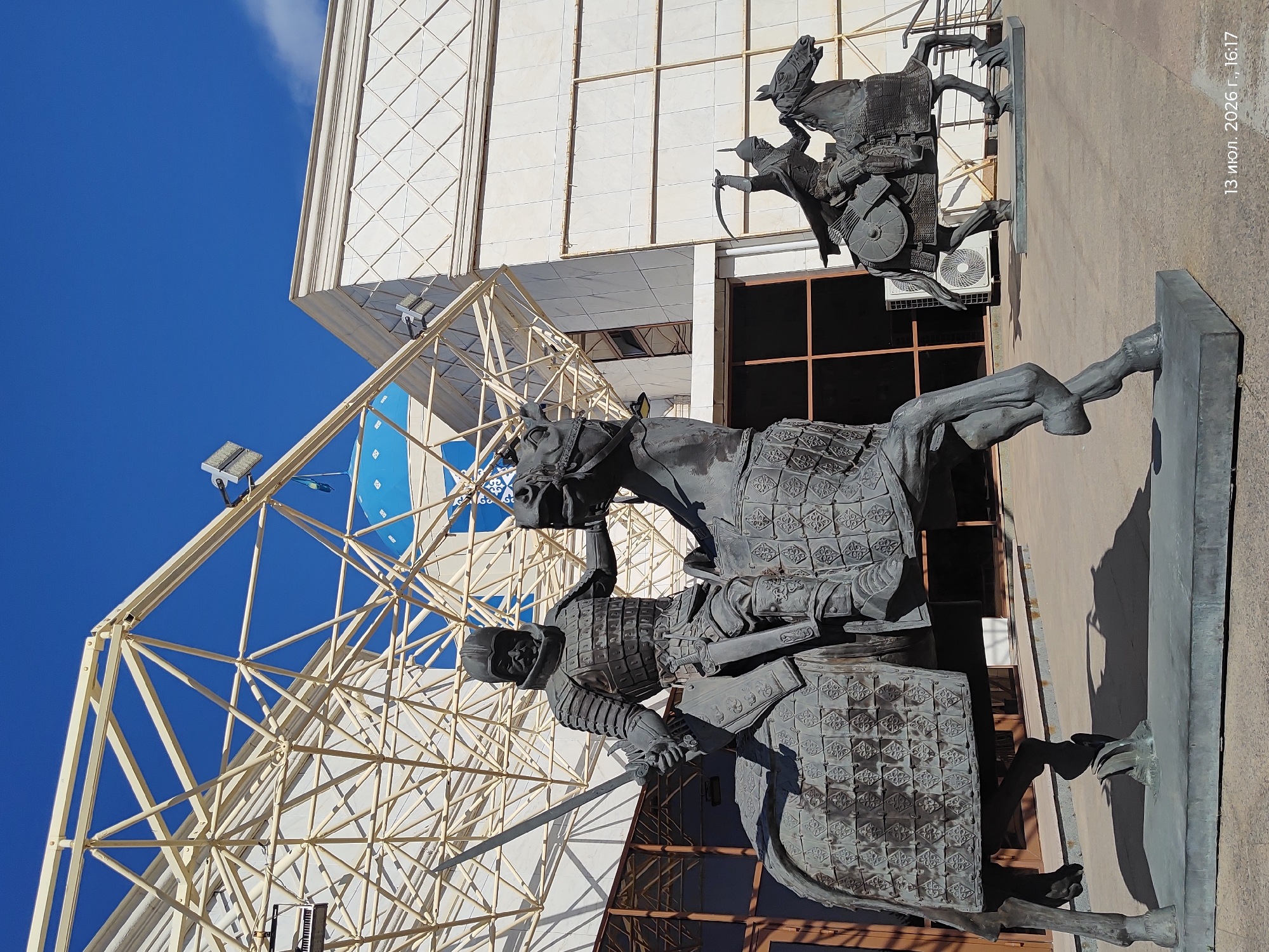 Armored equestrian statues outside a modern Astana building