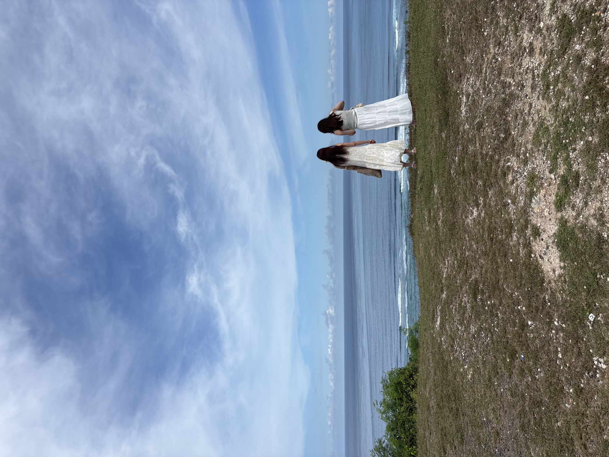 Two women photograph coastal visit in Kuta Selatan