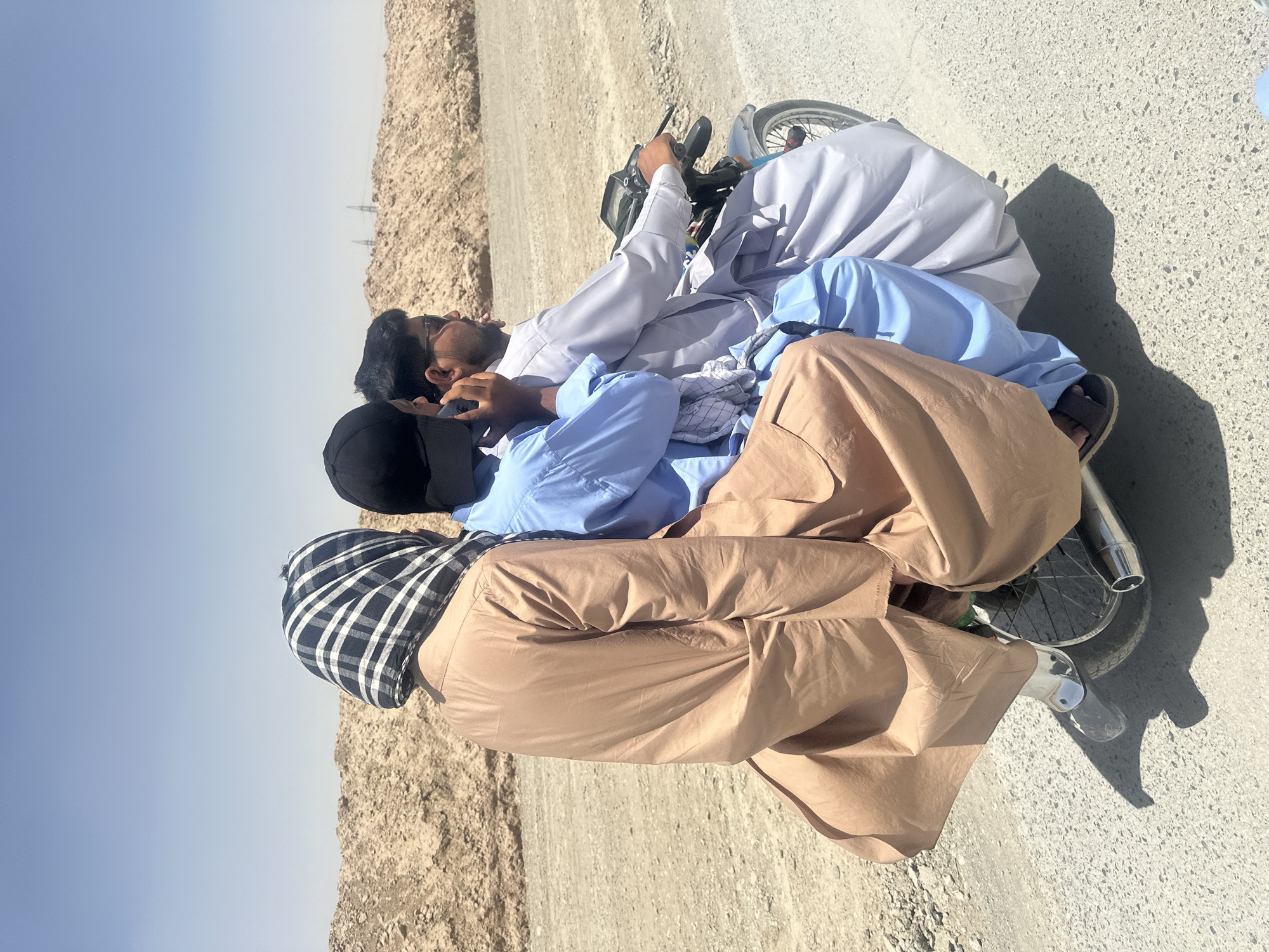 Three men rest roadside in Yaru Karez, Pakistan