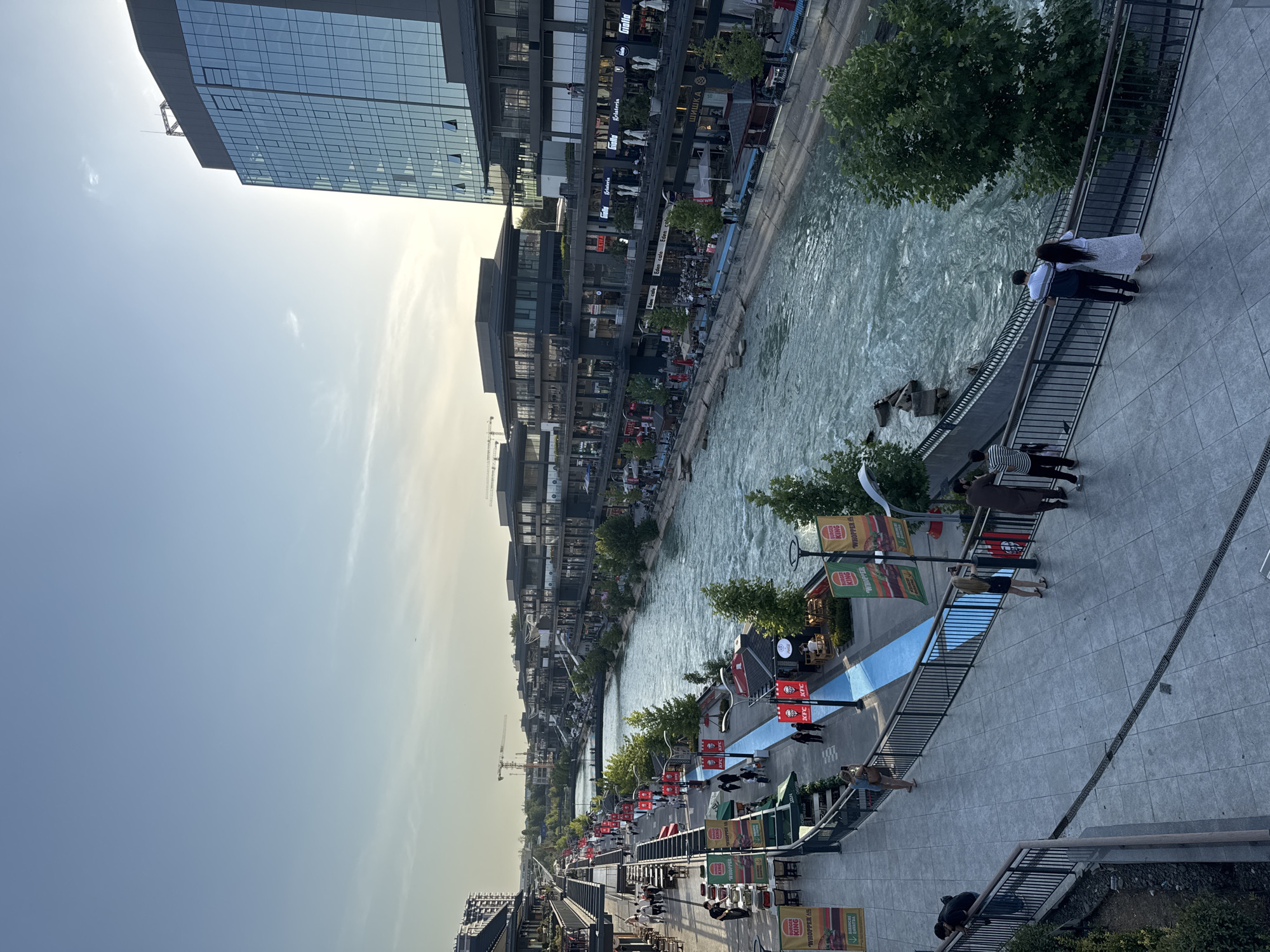 Riverside promenade and mall buzz with food mascots and foot traffic