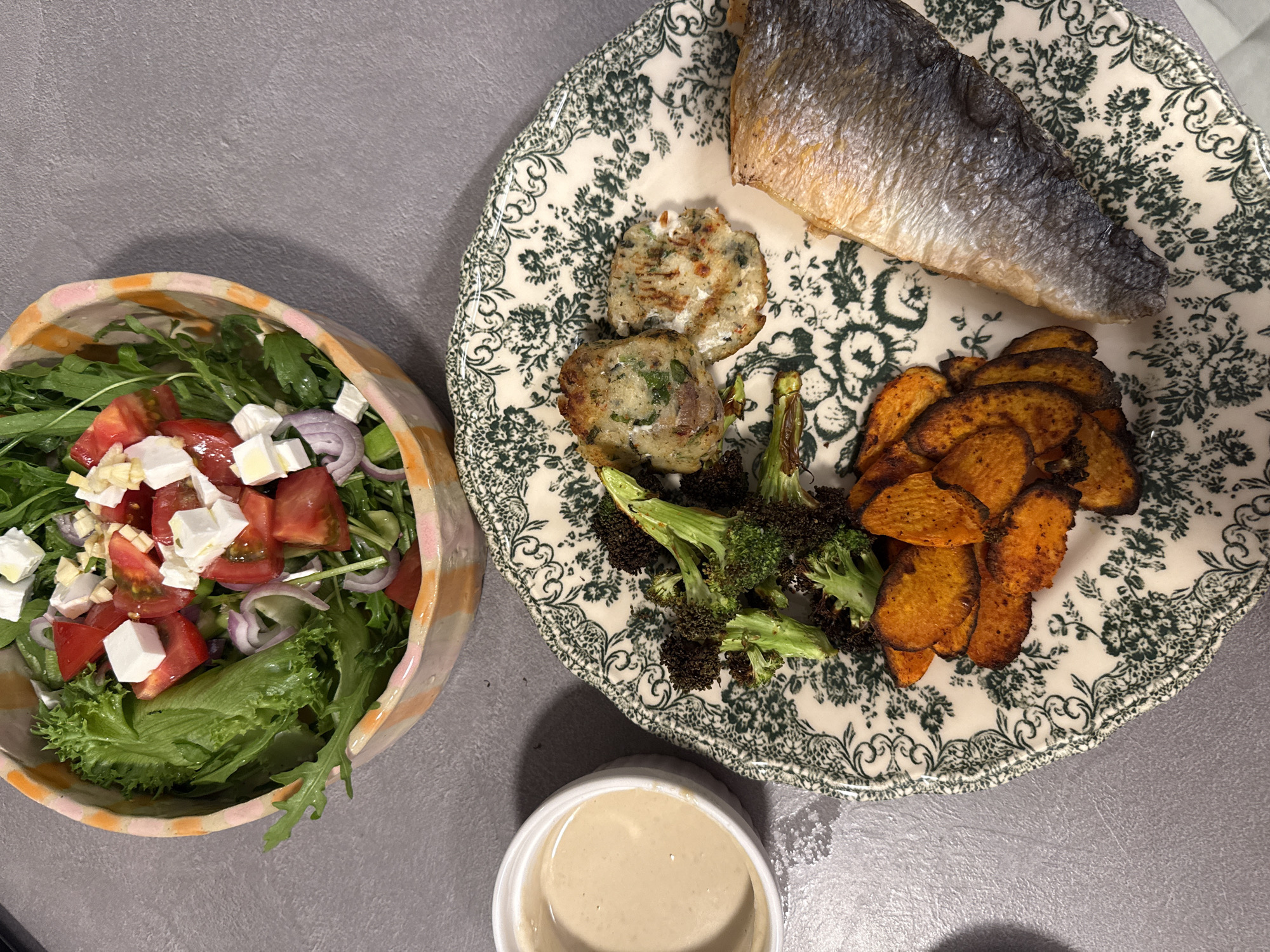 Home-cooked meal documented featuring fish, vegetables, and potato cakes