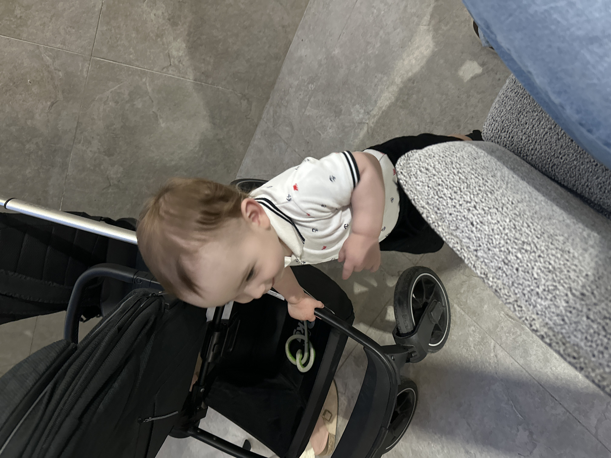 Toddler explores downtown Chișinău near modern buildings and restaurant