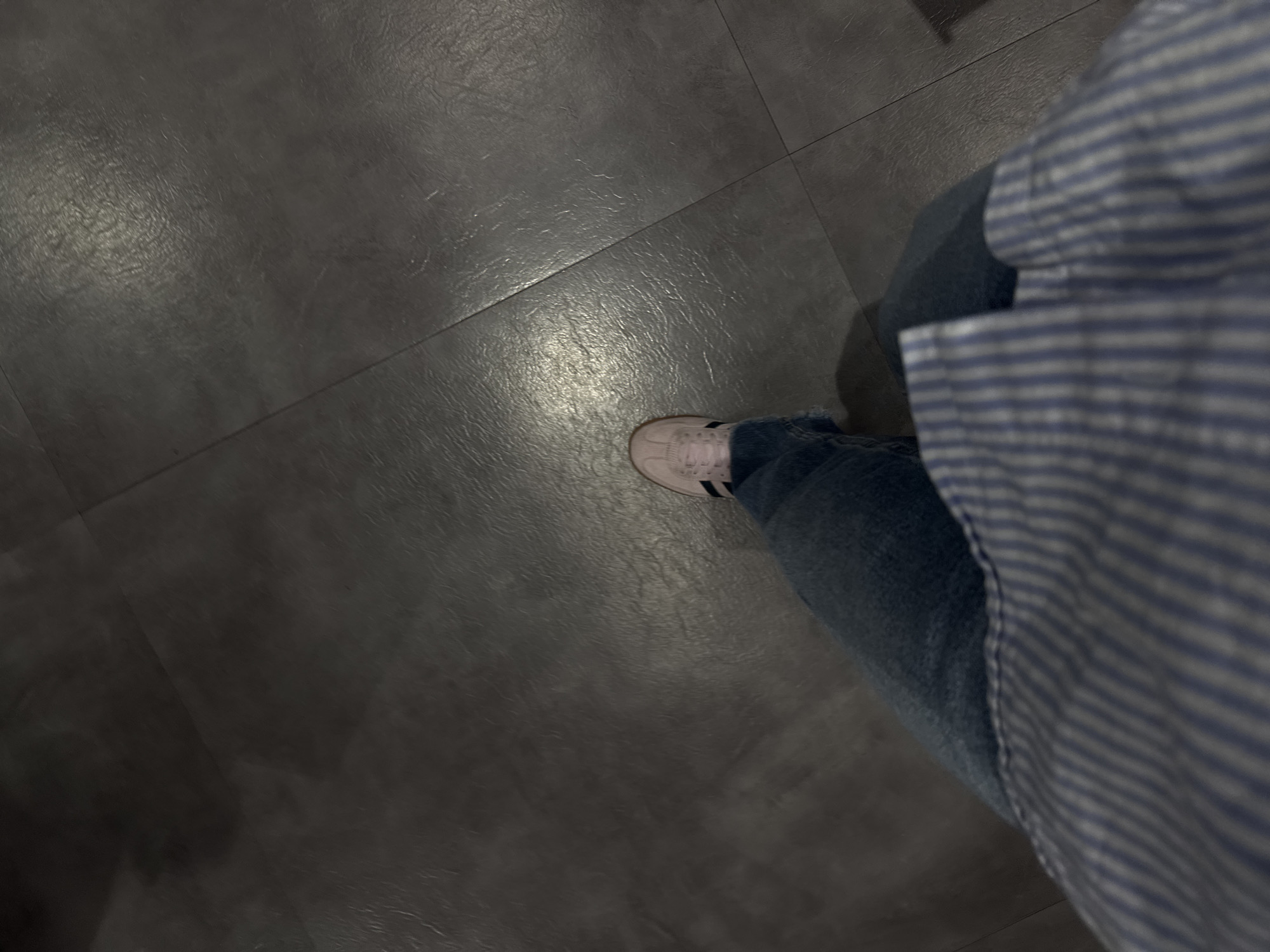 Person in striped shirt observed on tiled floor