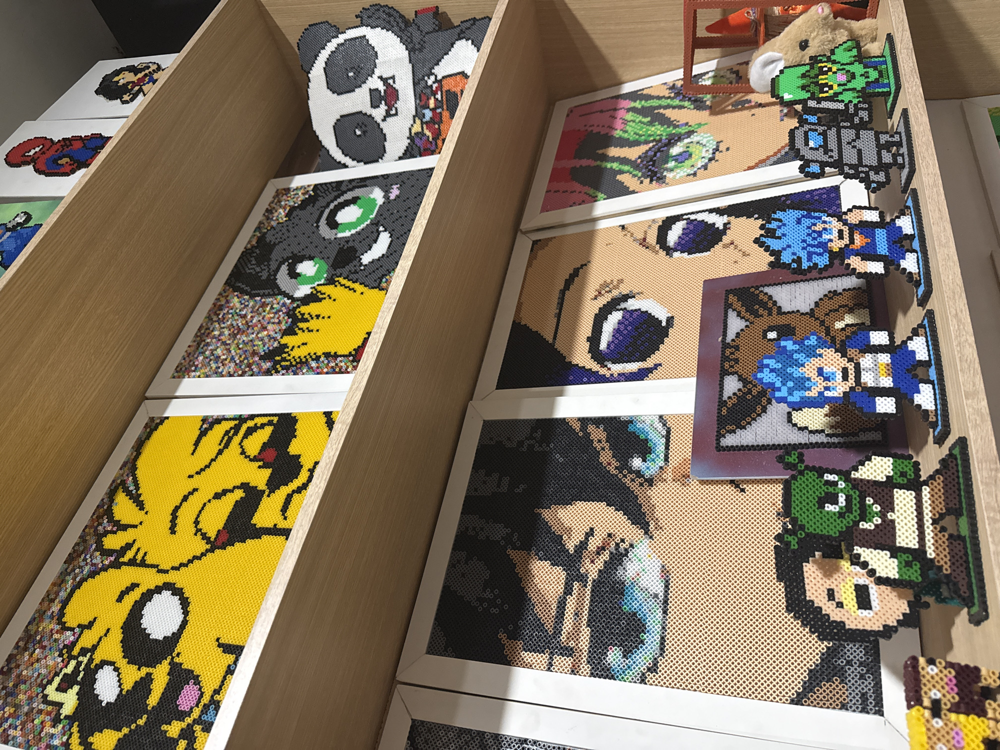 Perler bead anime artwork displayed on shelves in Puebla