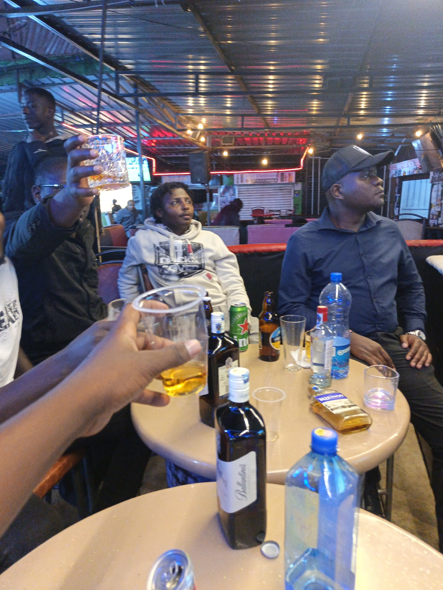 Men socialize over drinks at Nairobi bar Thursday evening