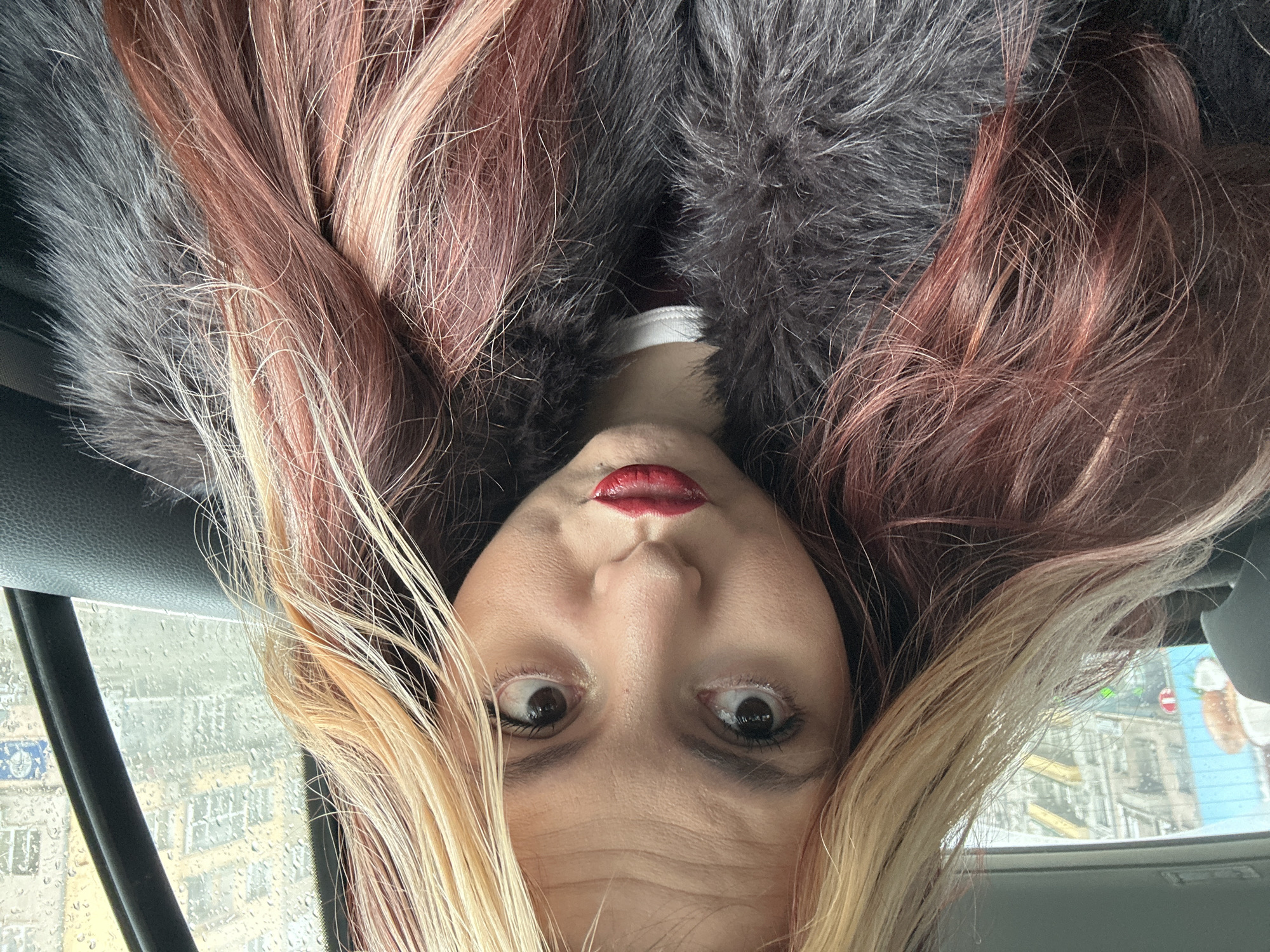Woman takes upside-down selfies in car during rainy Sofia morning