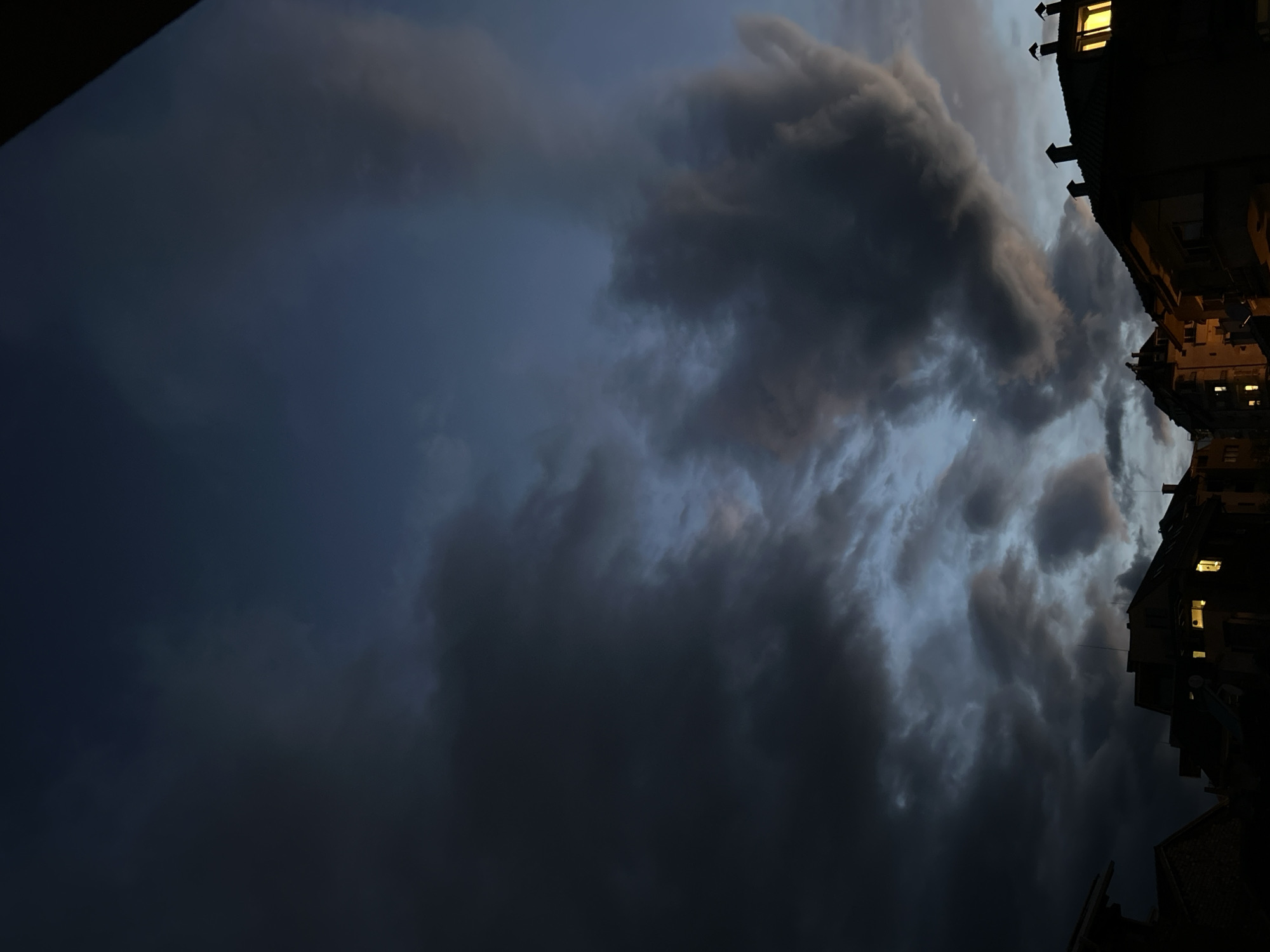 Storm clouds gather over city as evening approaches