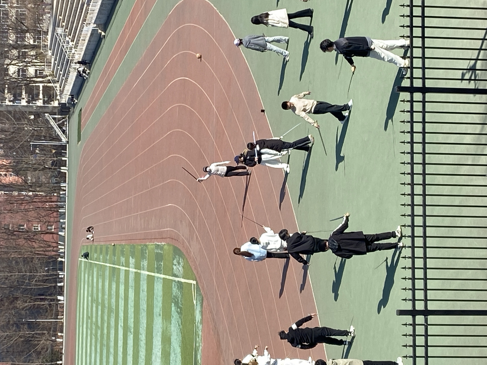Group practices martial arts, fencing at Chinese stadium