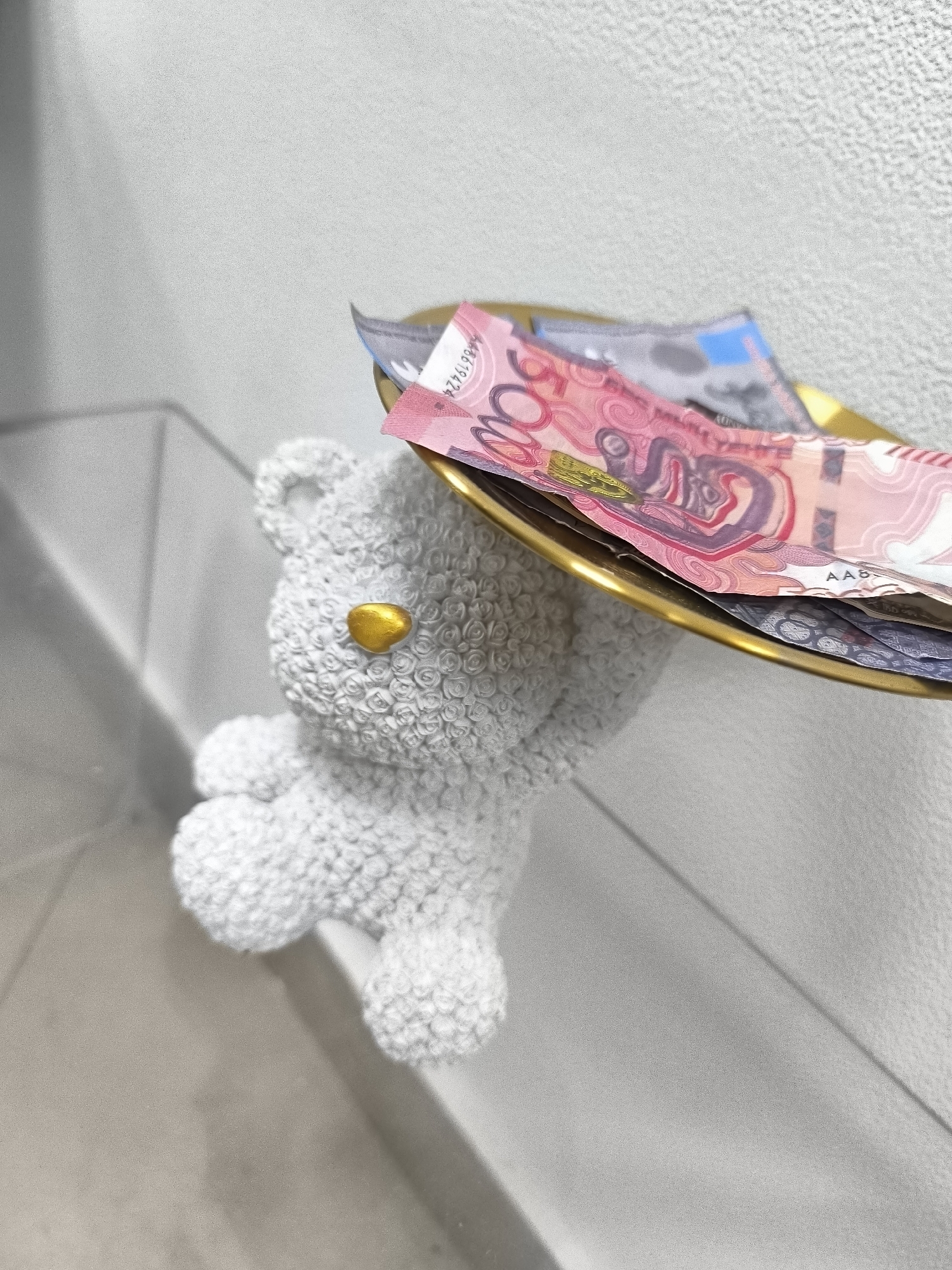 Teddy bear figurine holds tray of banknotes at Karaganda city hall