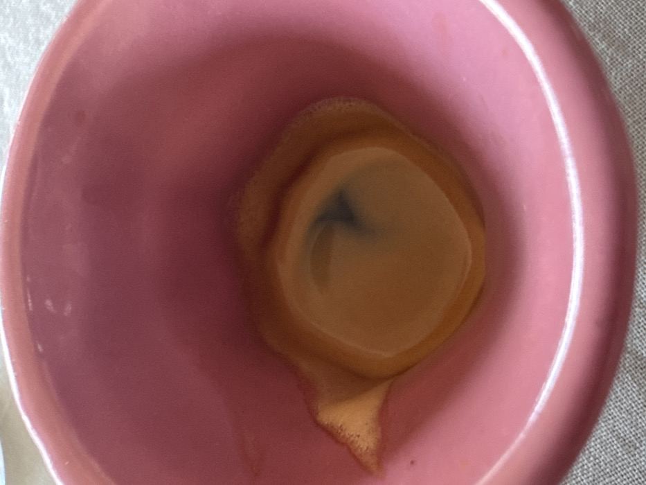 Pink mug with marked brown liquid photographed in London
