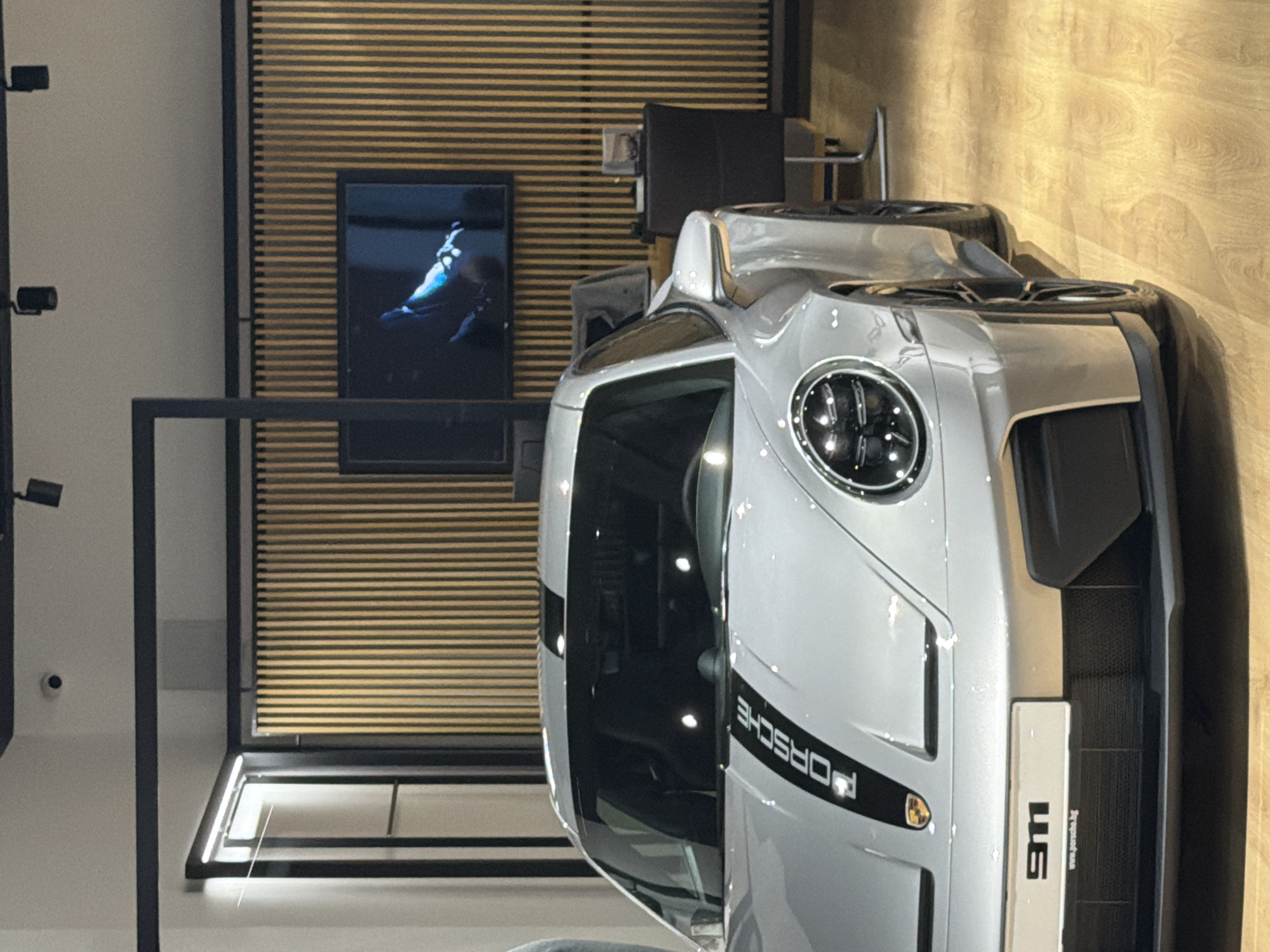 Two men view silver Porsche display in Varna showroom