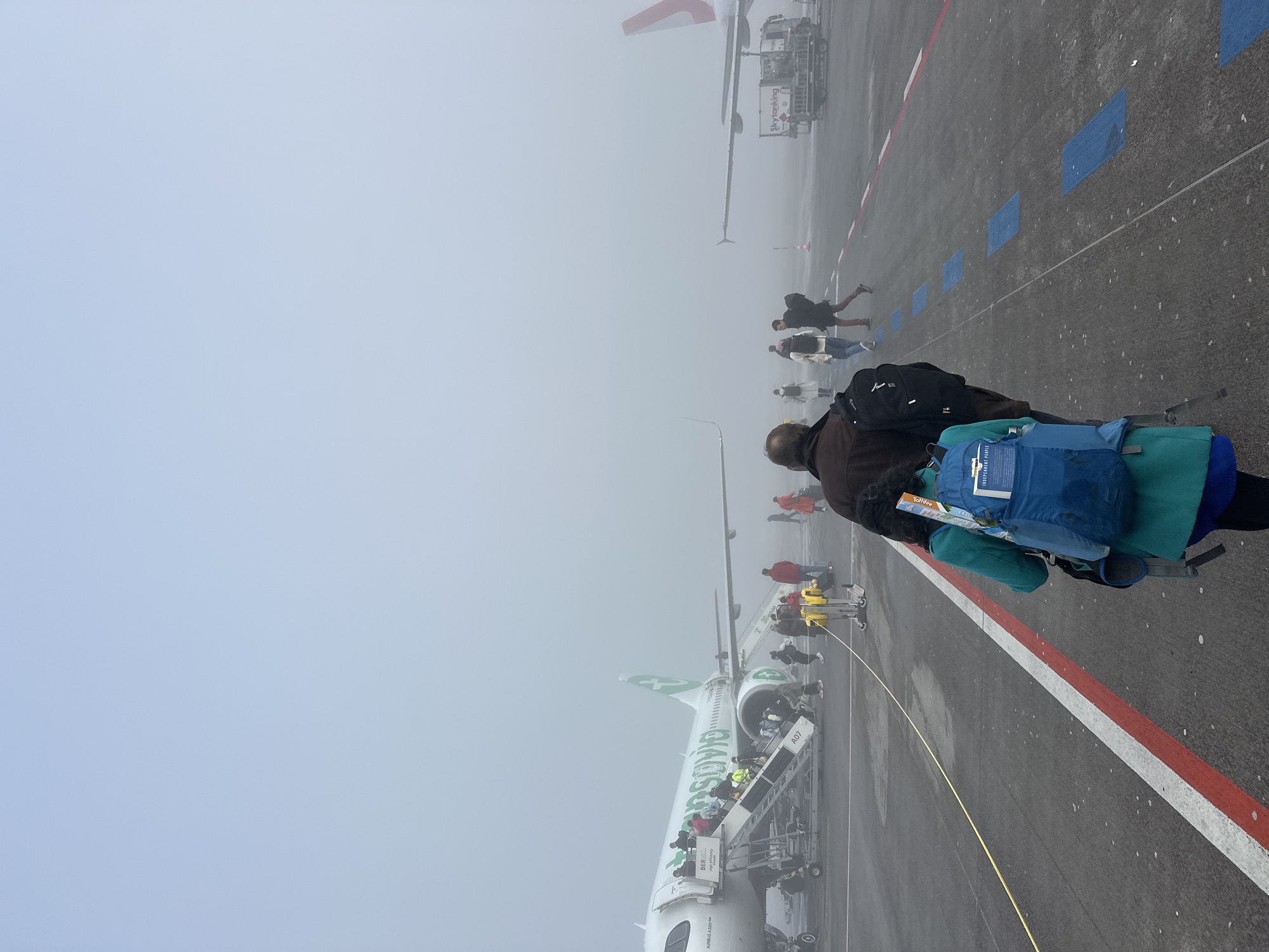 Passengers disembark Transavia flight amid fog at Berlin airport