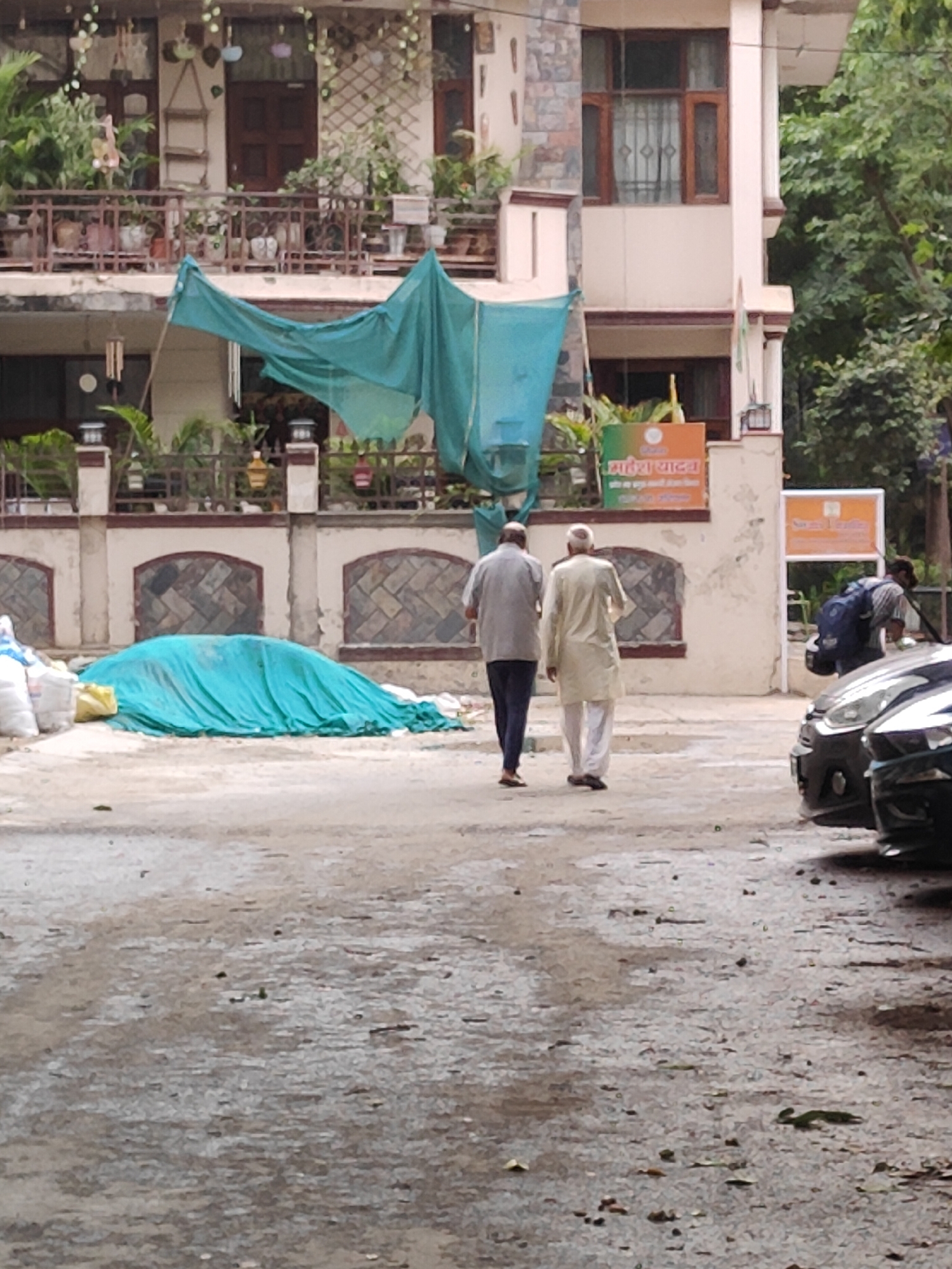 Daytime street scene near a multi-story building in Gurgaon