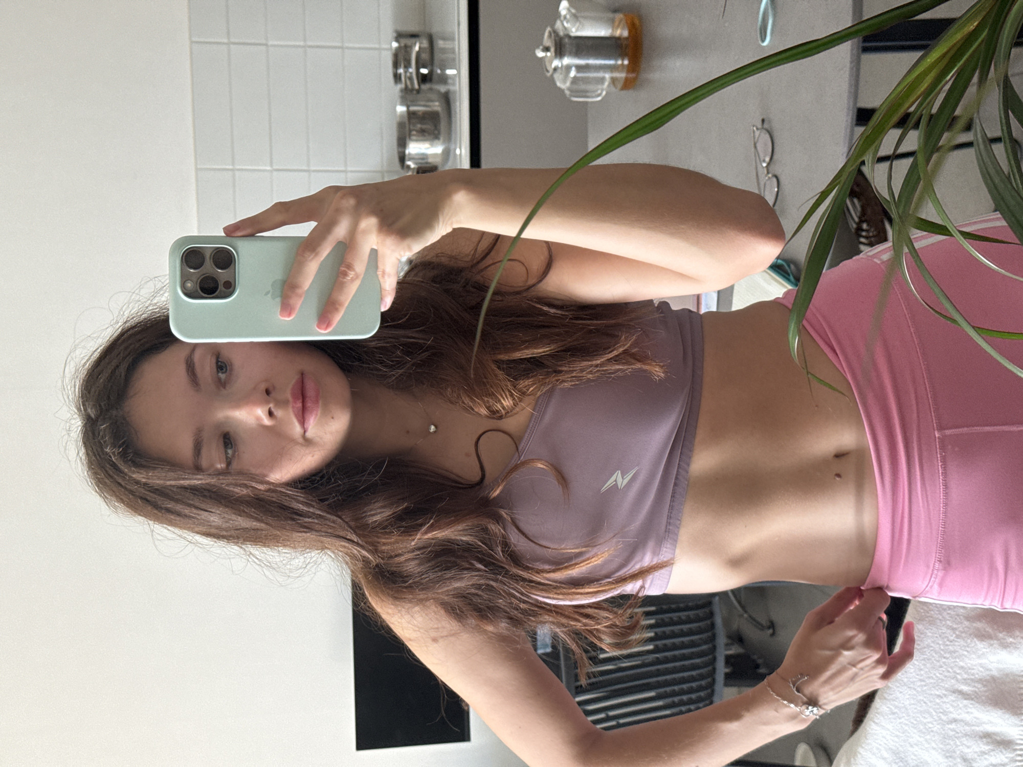 Young woman takes mirror selfie with green iPhone