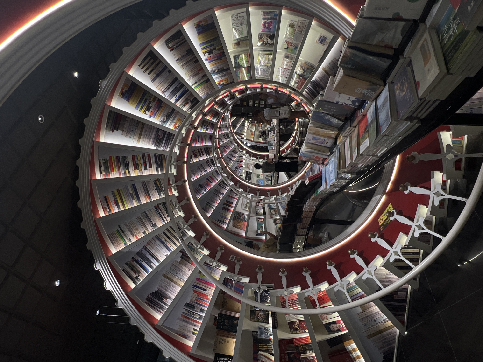 Woman with baby visits spiral staircase bookstore in Bao'an