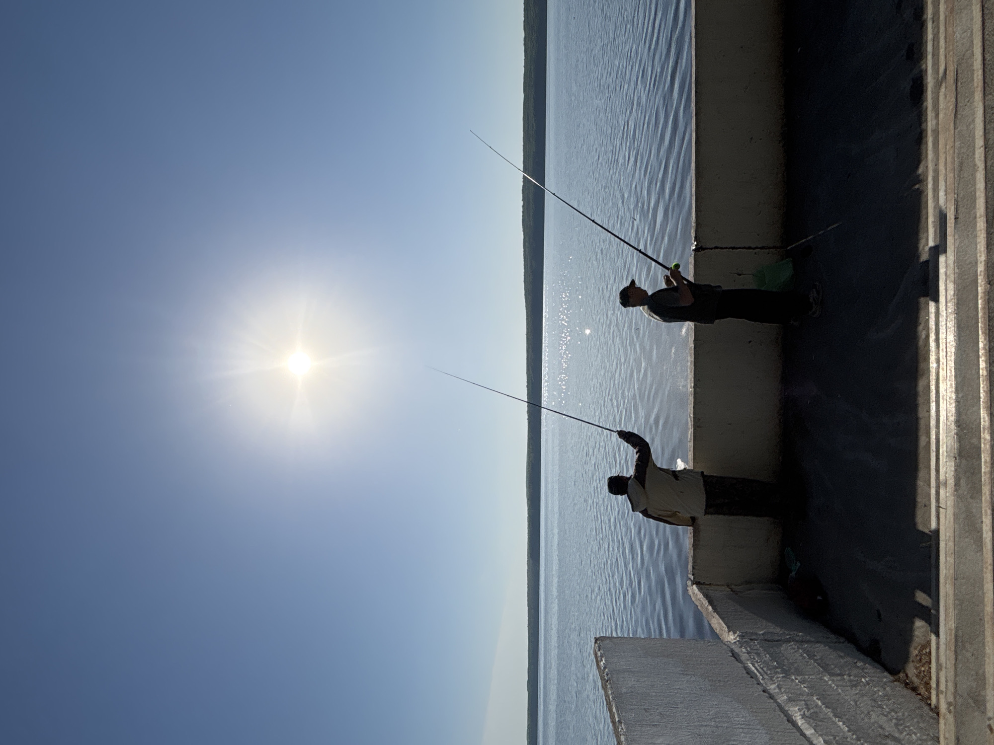 Two men fish from pier in Chaikovsky, Russia