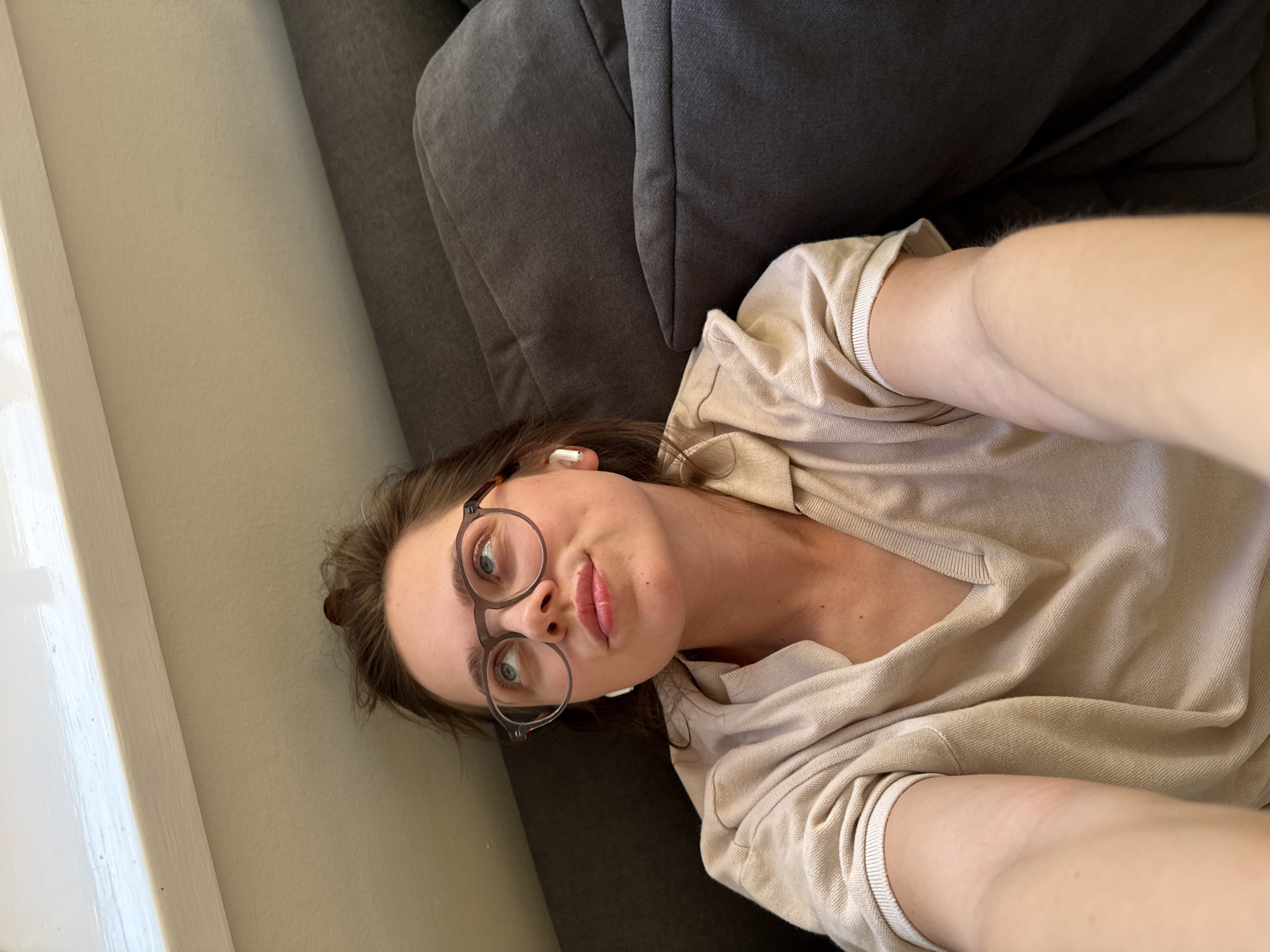 Woman takes casual selfies on couch in Budapest home