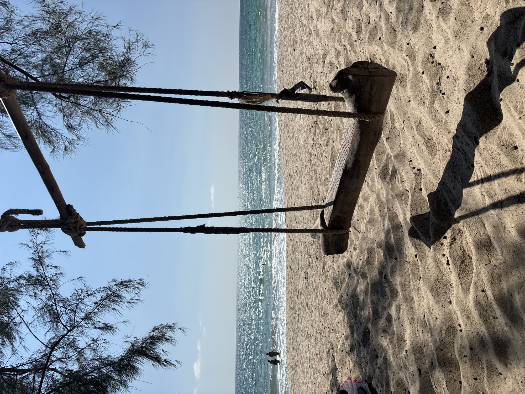 Wooden swing overlooks sandy beach in Choeng Thale, Thailand