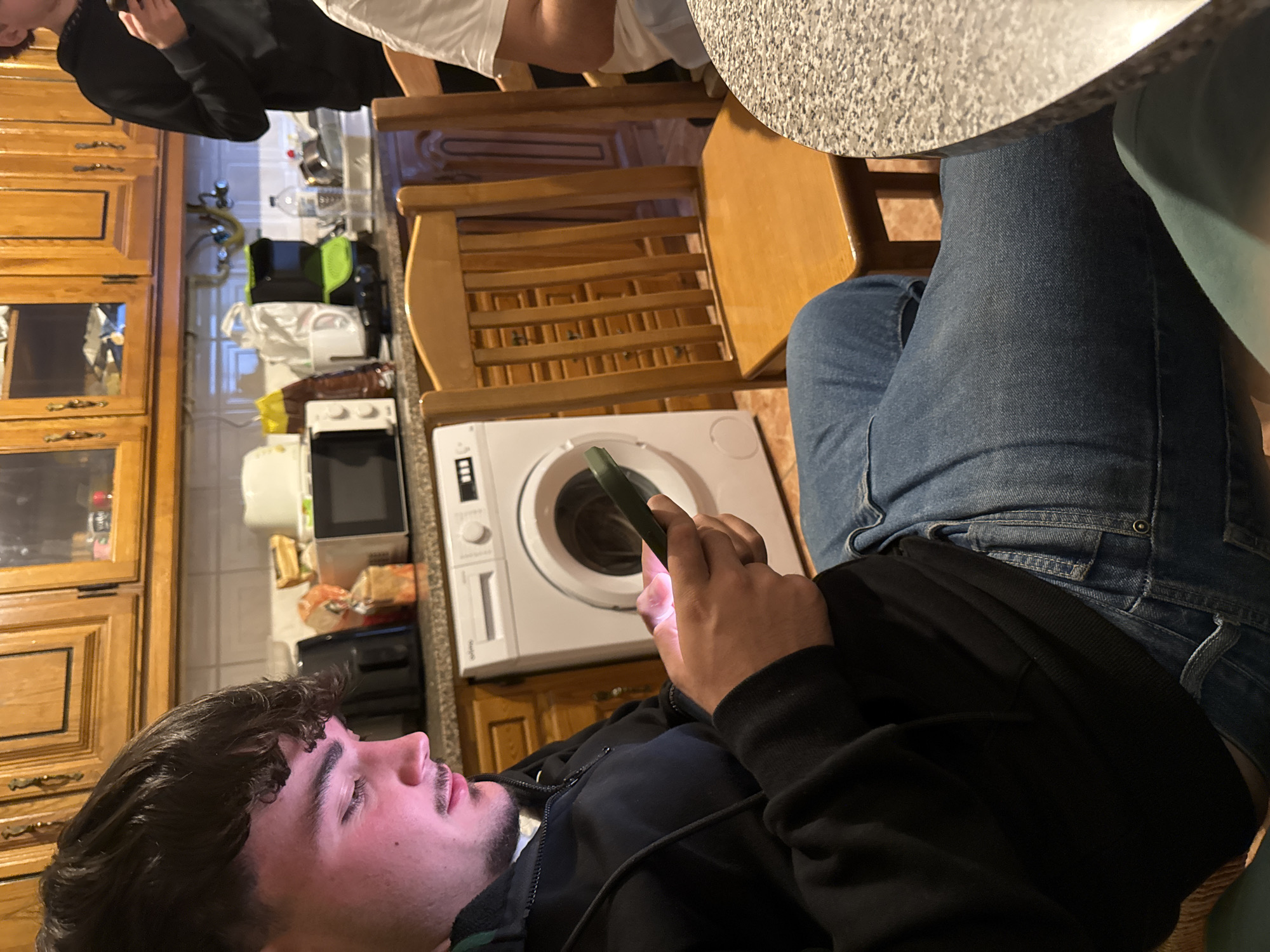 Young men gather in Bragança kitchen evening scene