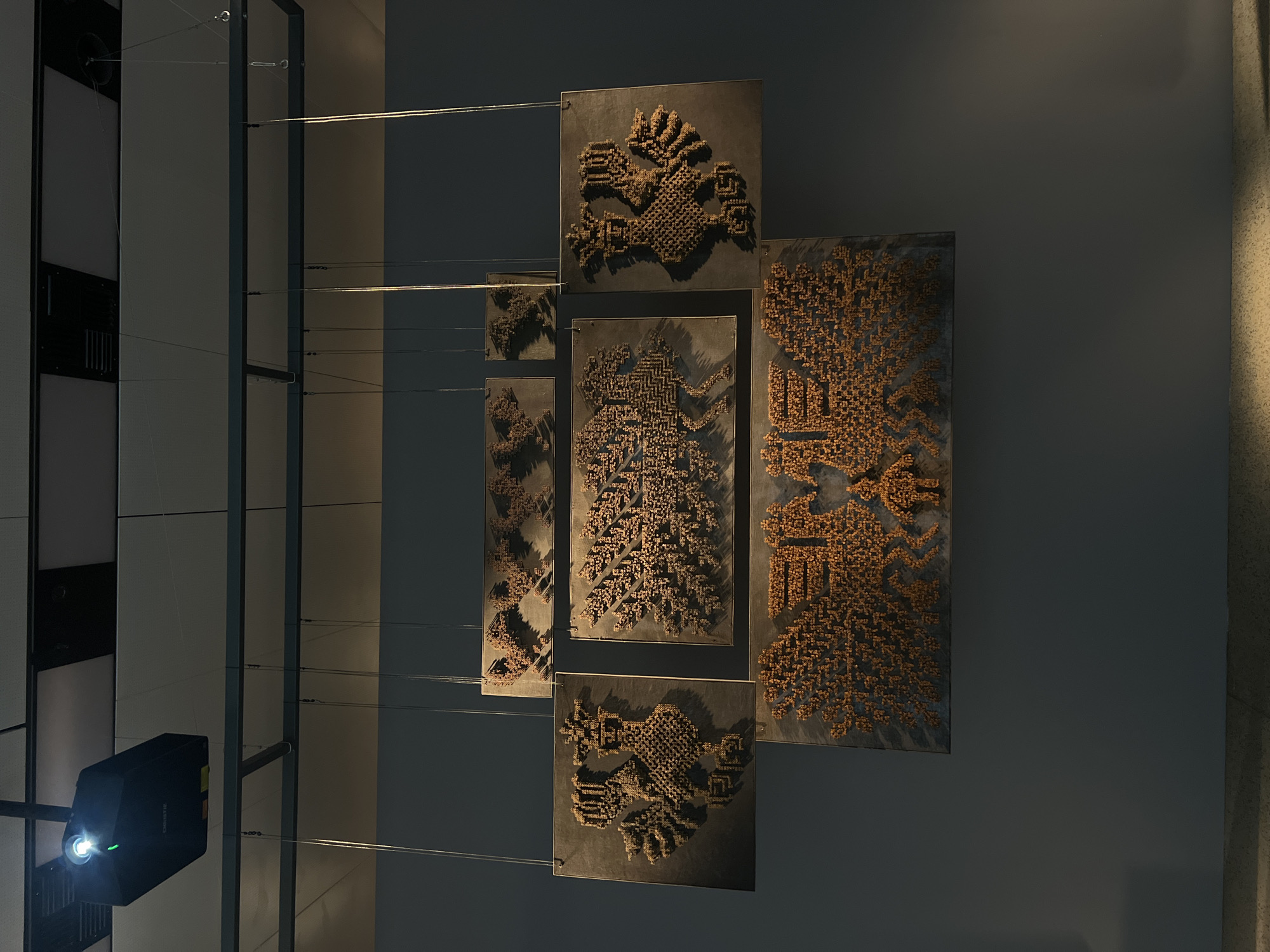 Cross-shaped art installation displayed in museum gallery ceiling