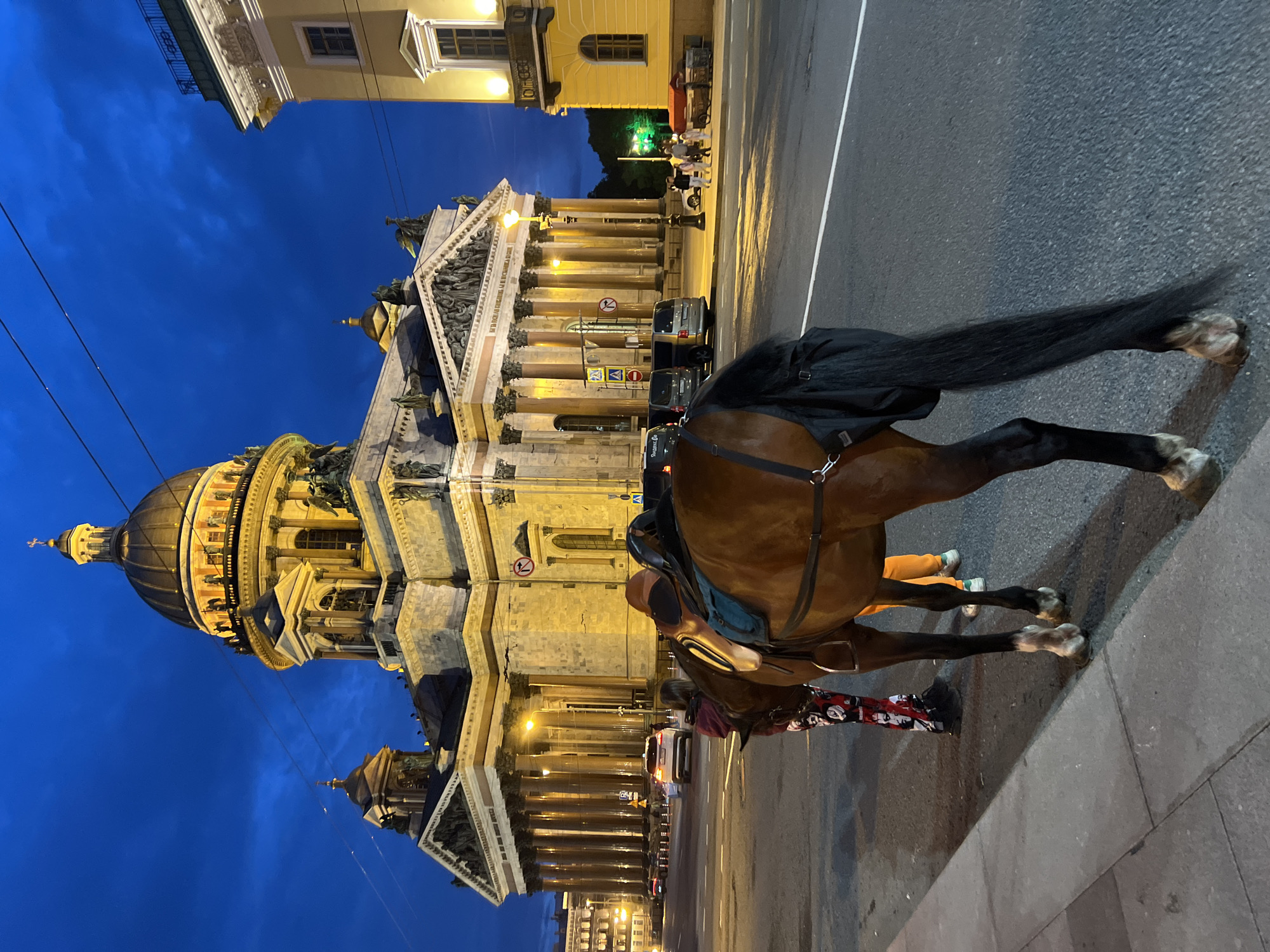 St. Isaac's Cathedral at dusk, with Saint Petersburg street life nearby