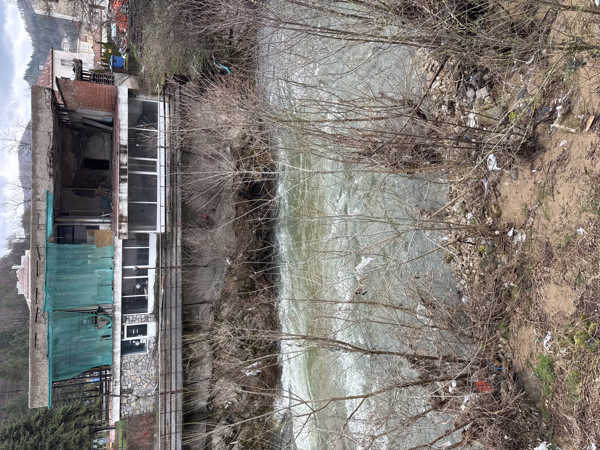 Fast-flowing river with debris observed in Rudozem, Bulgaria