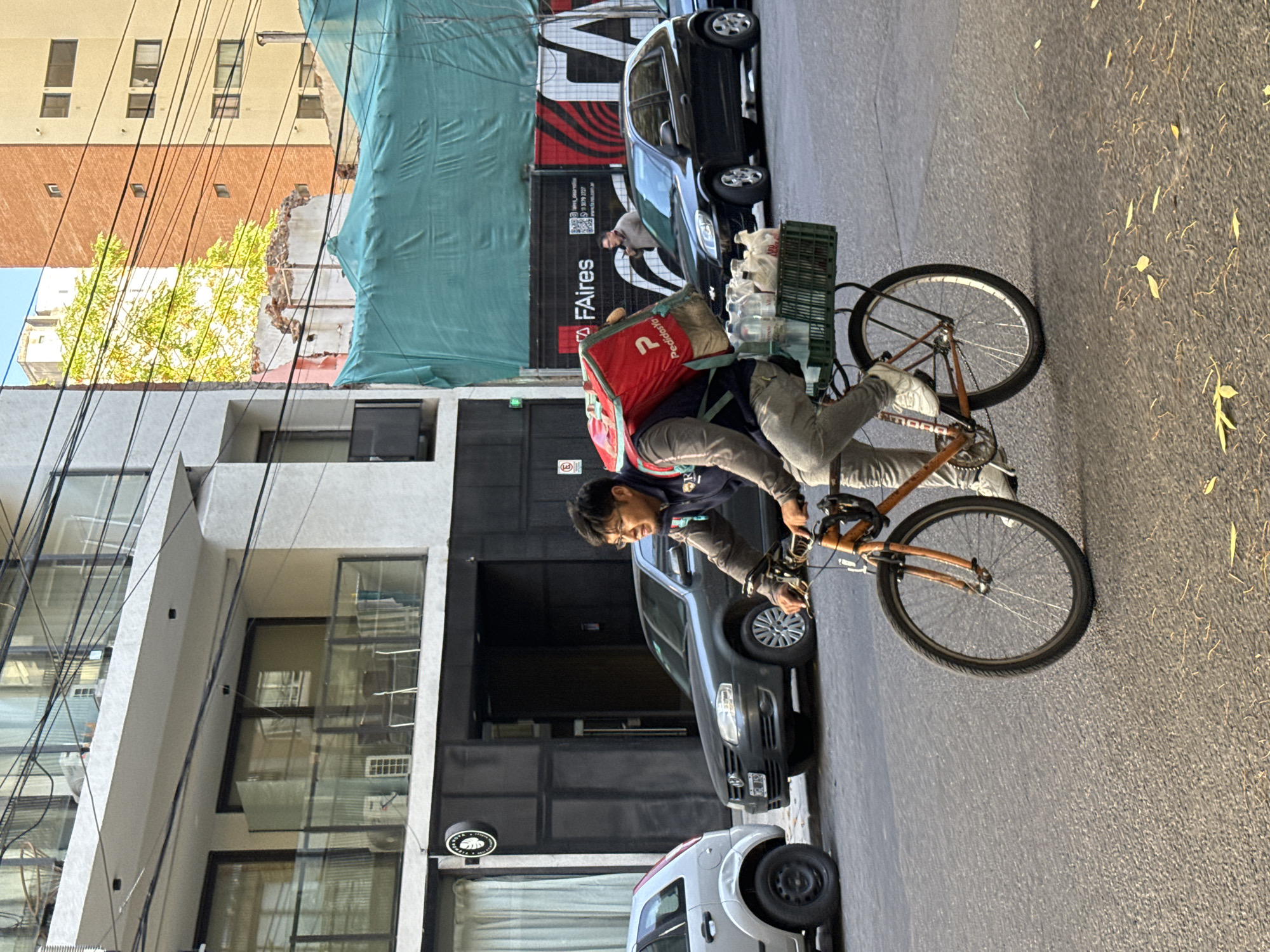 Delivery worker cycles through Buenos Aires street scene
