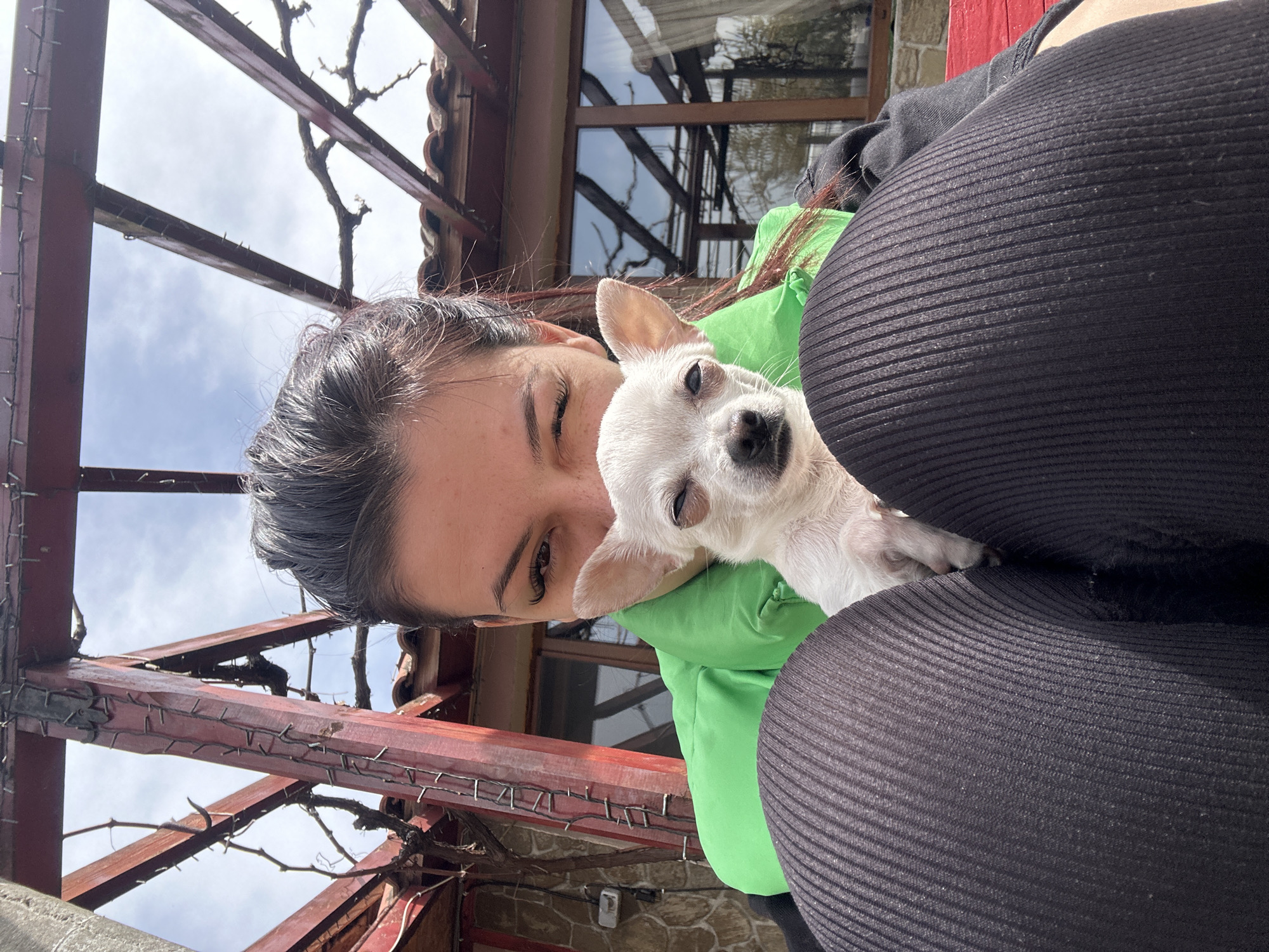 Woman poses with white Chihuahua on Bulgarian terrace