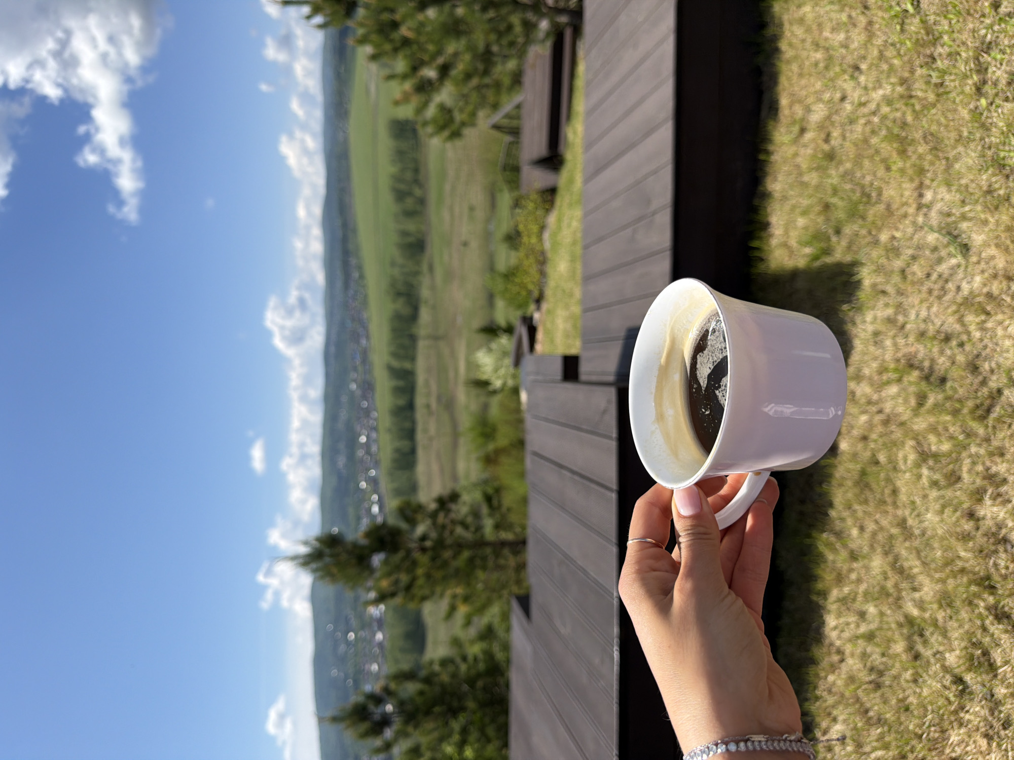 Woman enjoys morning coffee on wooden deck in Shamoni