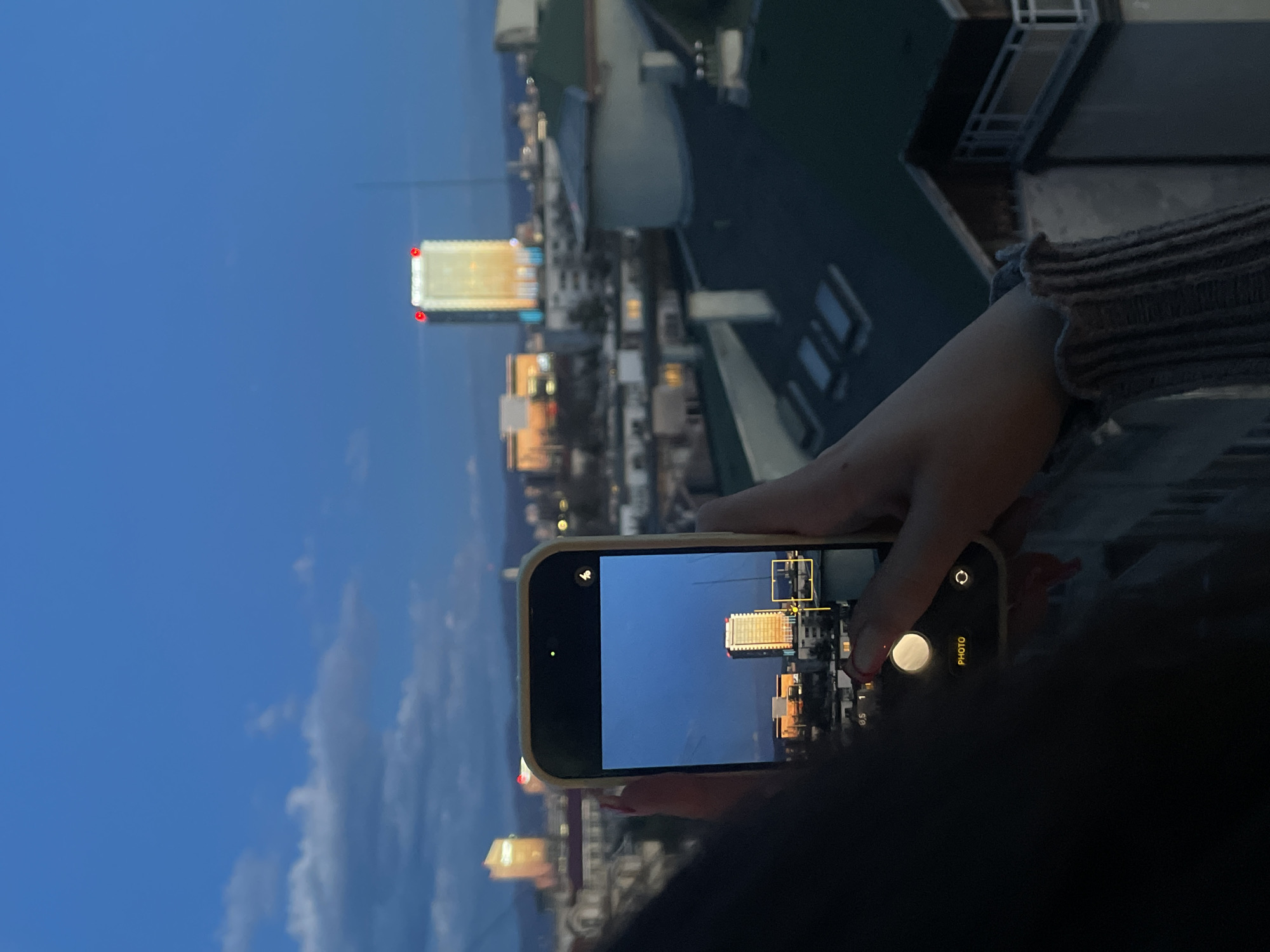 Tourist photographs Sofia skyline featuring East Plaza Hotel at dusk