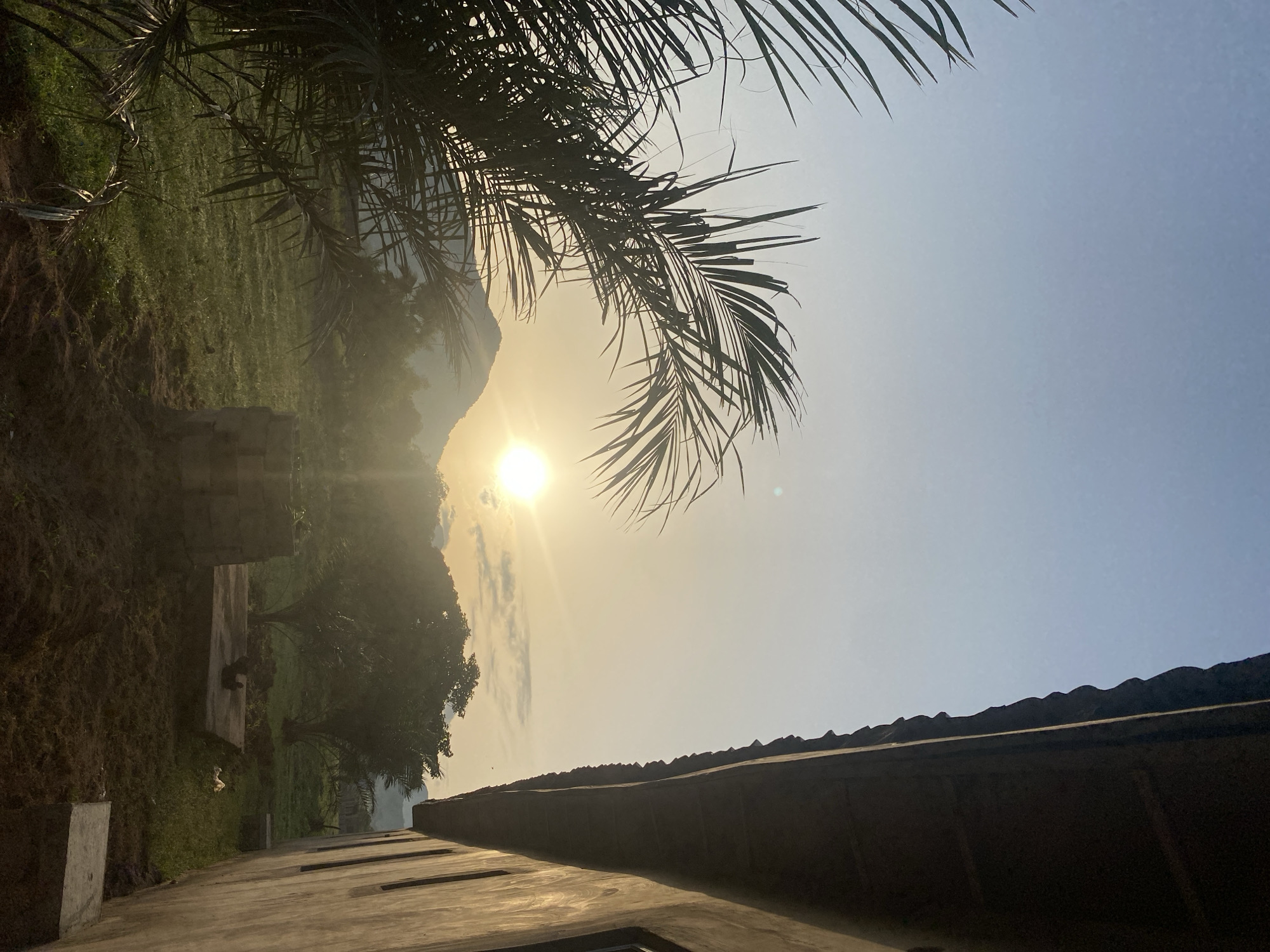 Sunrise over Tavo, Nigeria — palms, haze, and construction