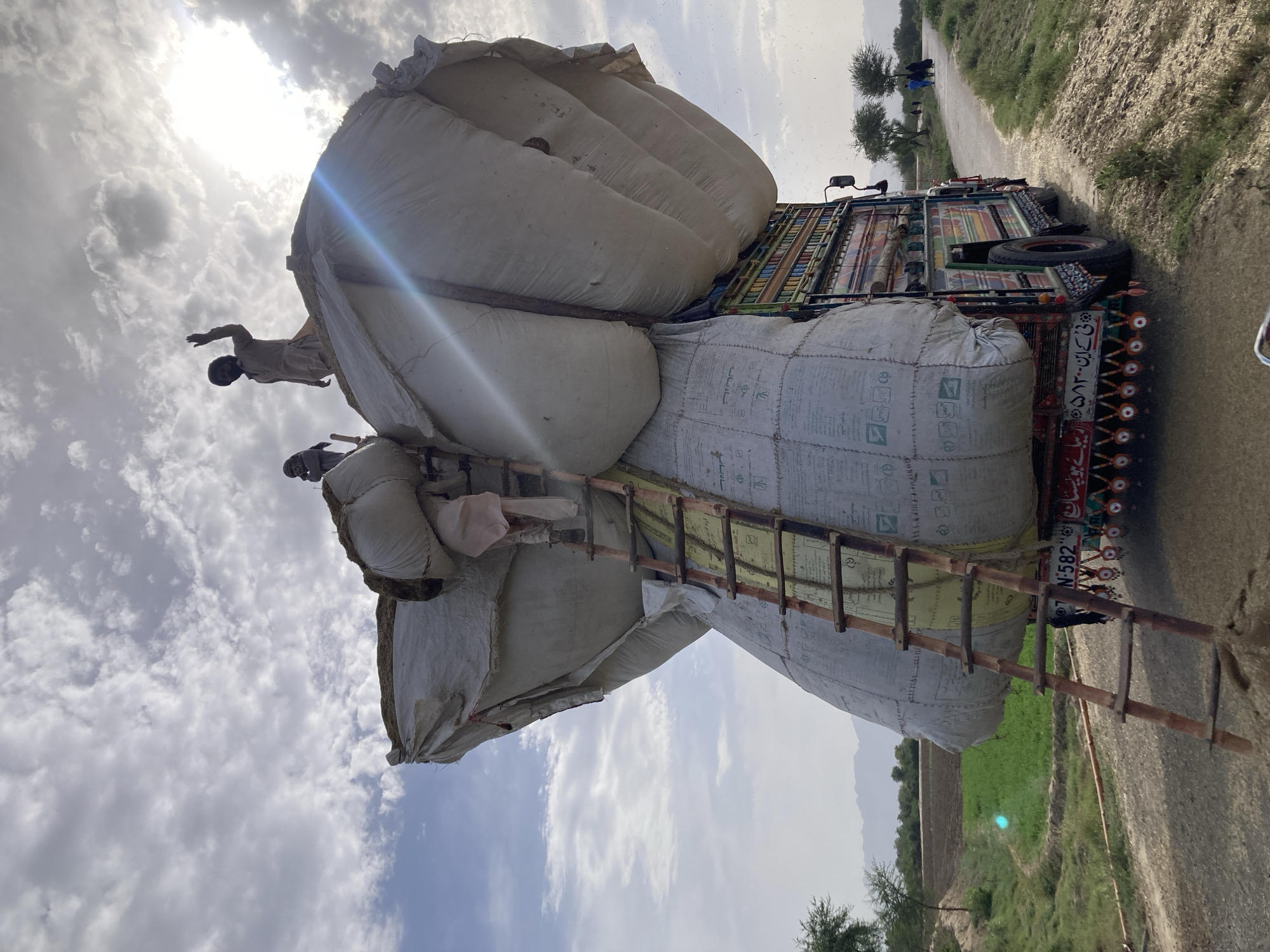 Workers load grain sacks onto decorated truck in Pakistan