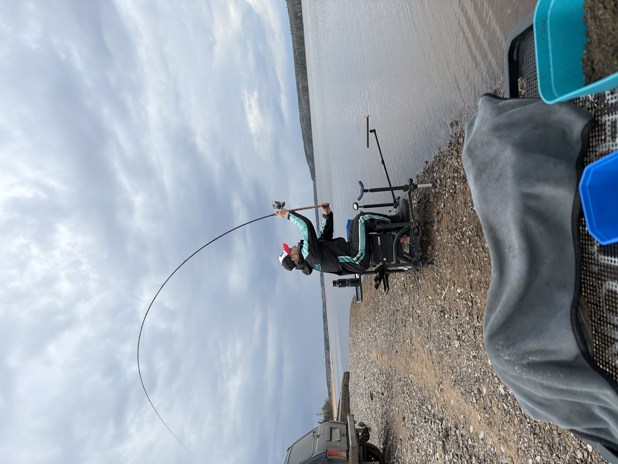 Angler fishes in rain along Chaikovsky waterway
